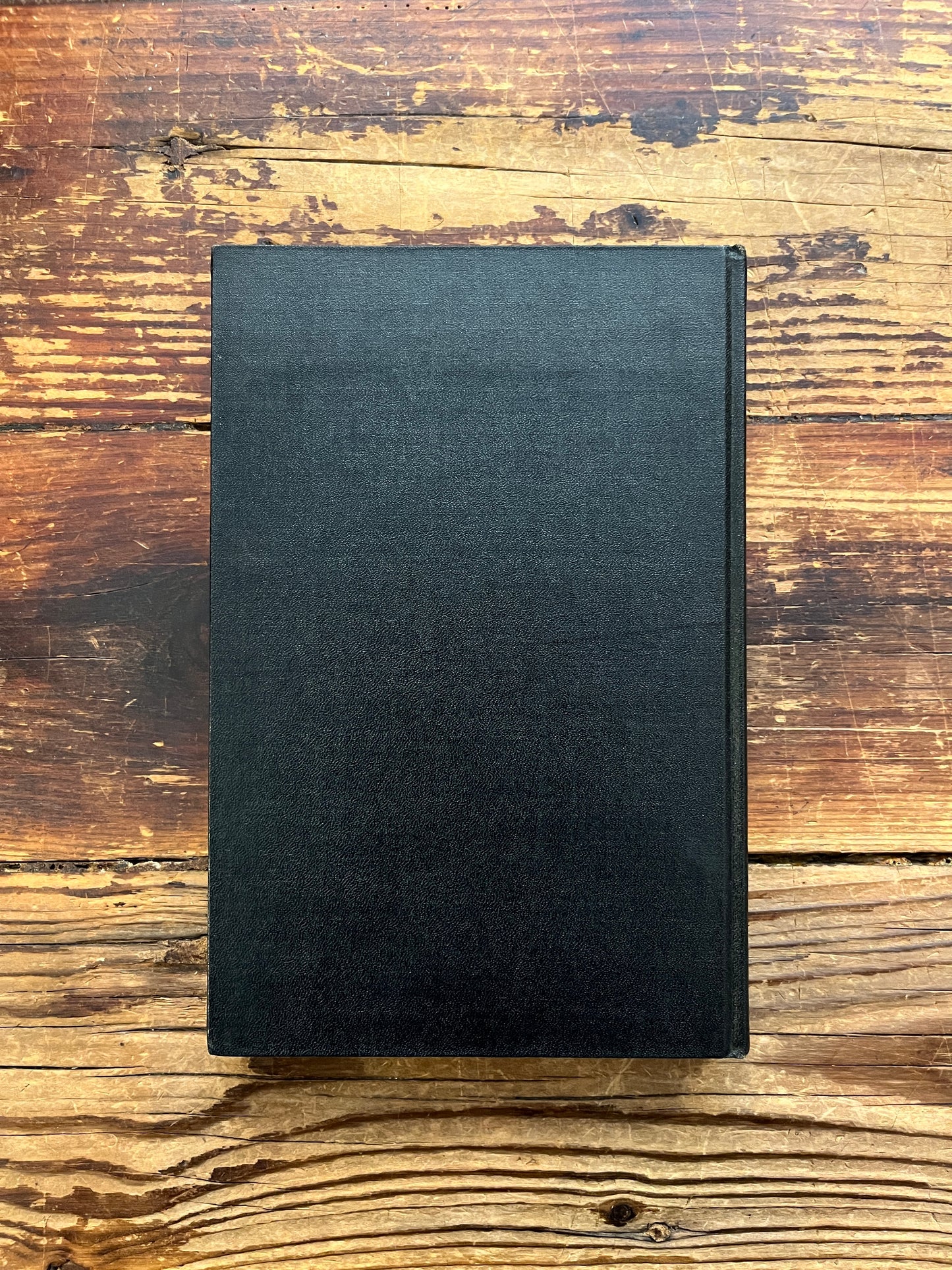 Back cover of book titled 'the philosopher's stone' by Israel Regardie on a wooden surface