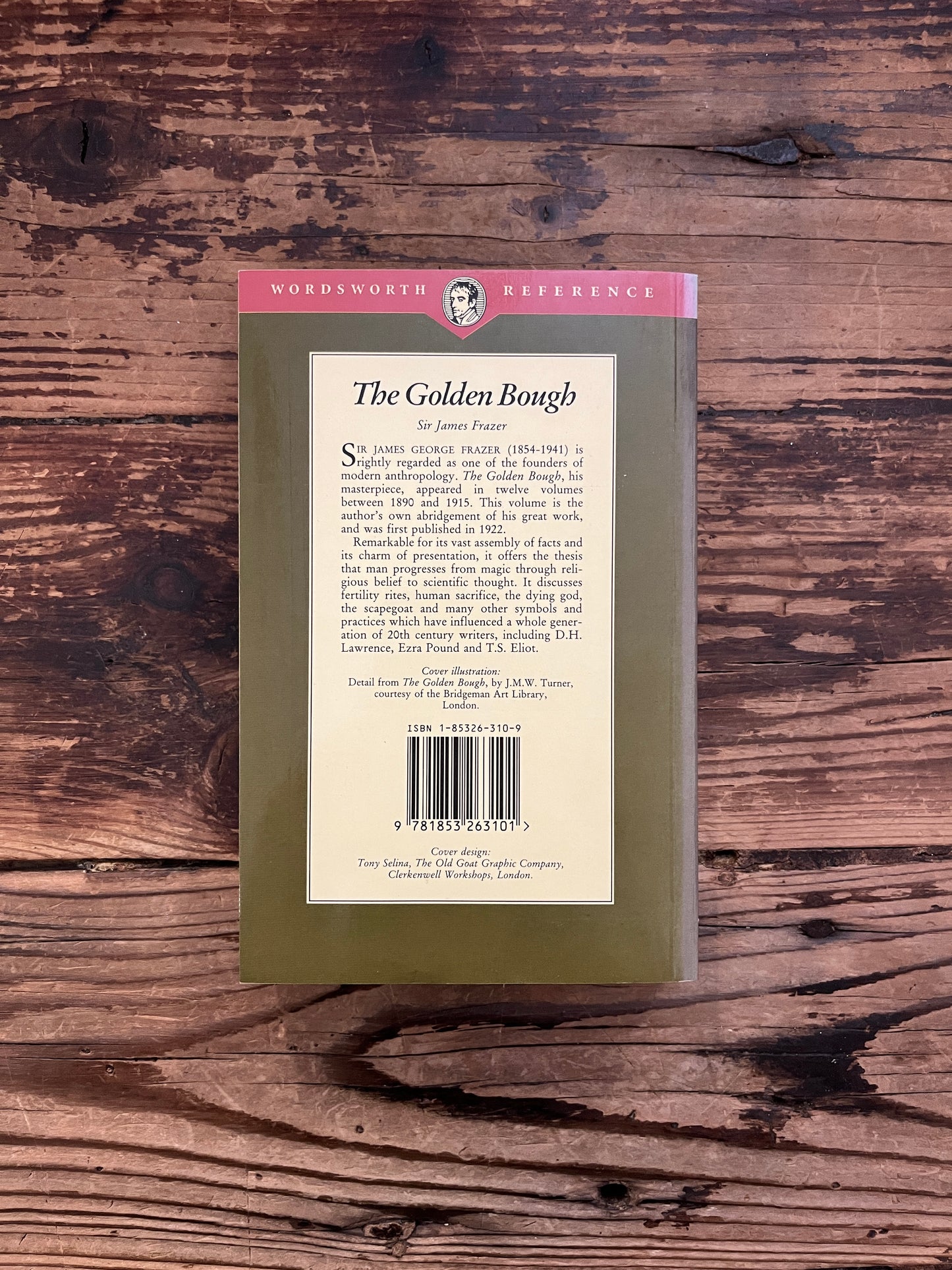 Back cover of book titled 'The Golden Bough' by James G. Frazer on a wooden surface