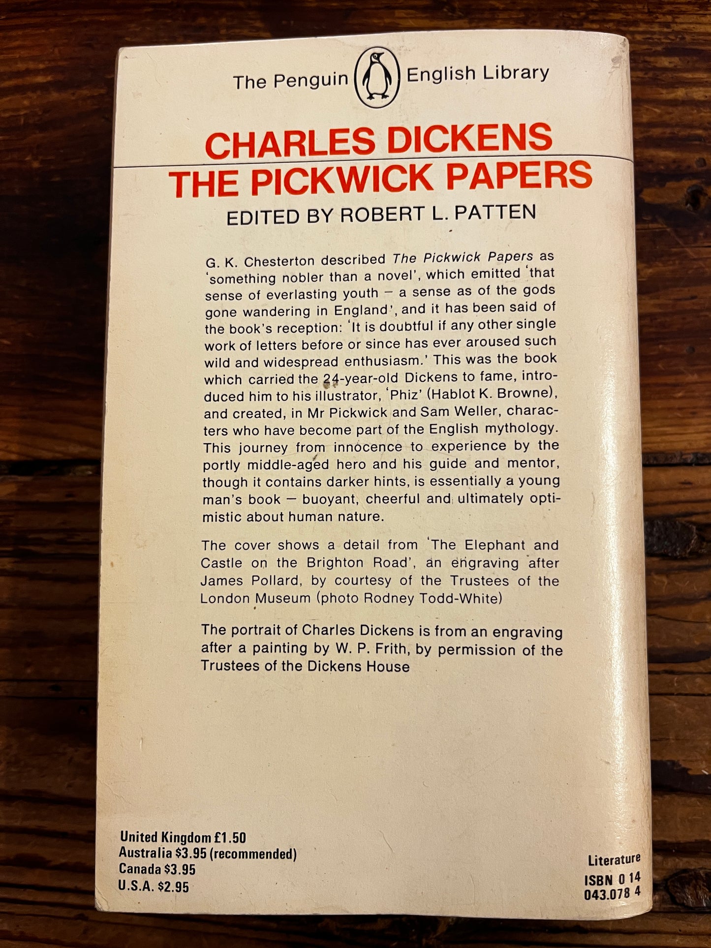 Back cover of book with the title 'The Pickwick papers' on a wooden surface