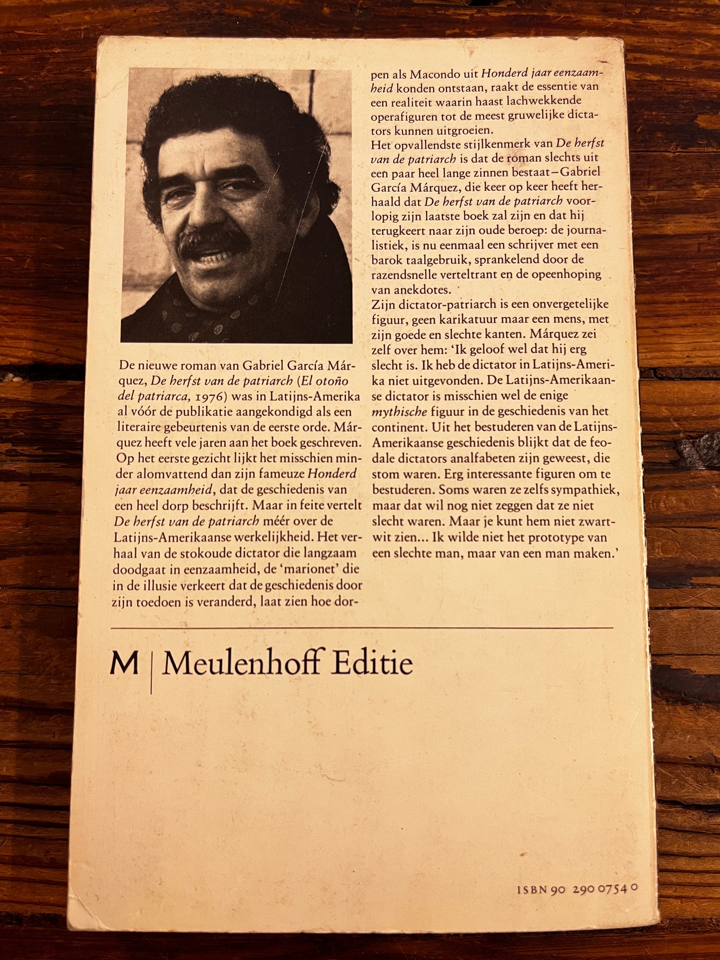 De achterkant van het boek 'De herfst van de patriarch' door Gabriel Garcia Marquez op een houten achtergrond