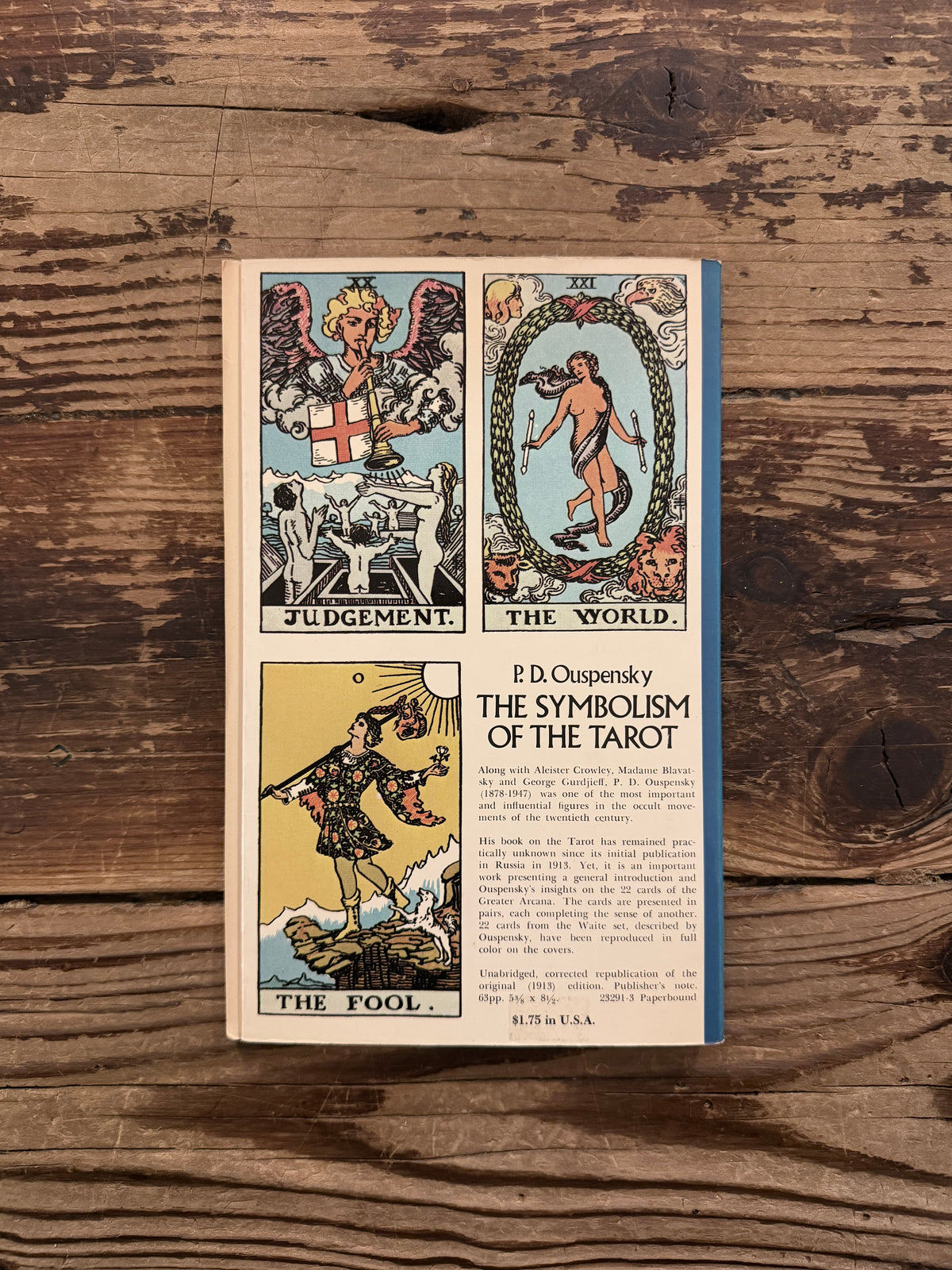 Last page with the tarot illustrations by Waite of a book with the title 'The symbolism of the Tarot, philosophy of Occultism in Pictures and Numbers' by P. D. Ouspensky, lying on a wooden surface