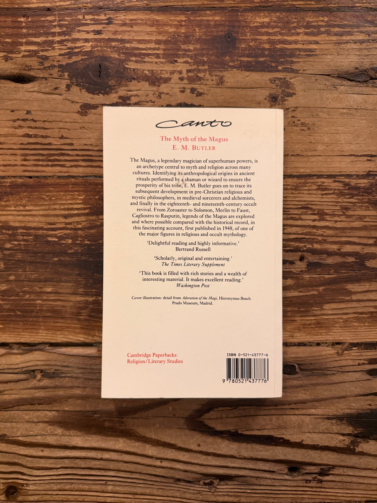 Back cover of a book with the title 'The Myth of the Magnus' by E.M. Butler lying on a wooden surface