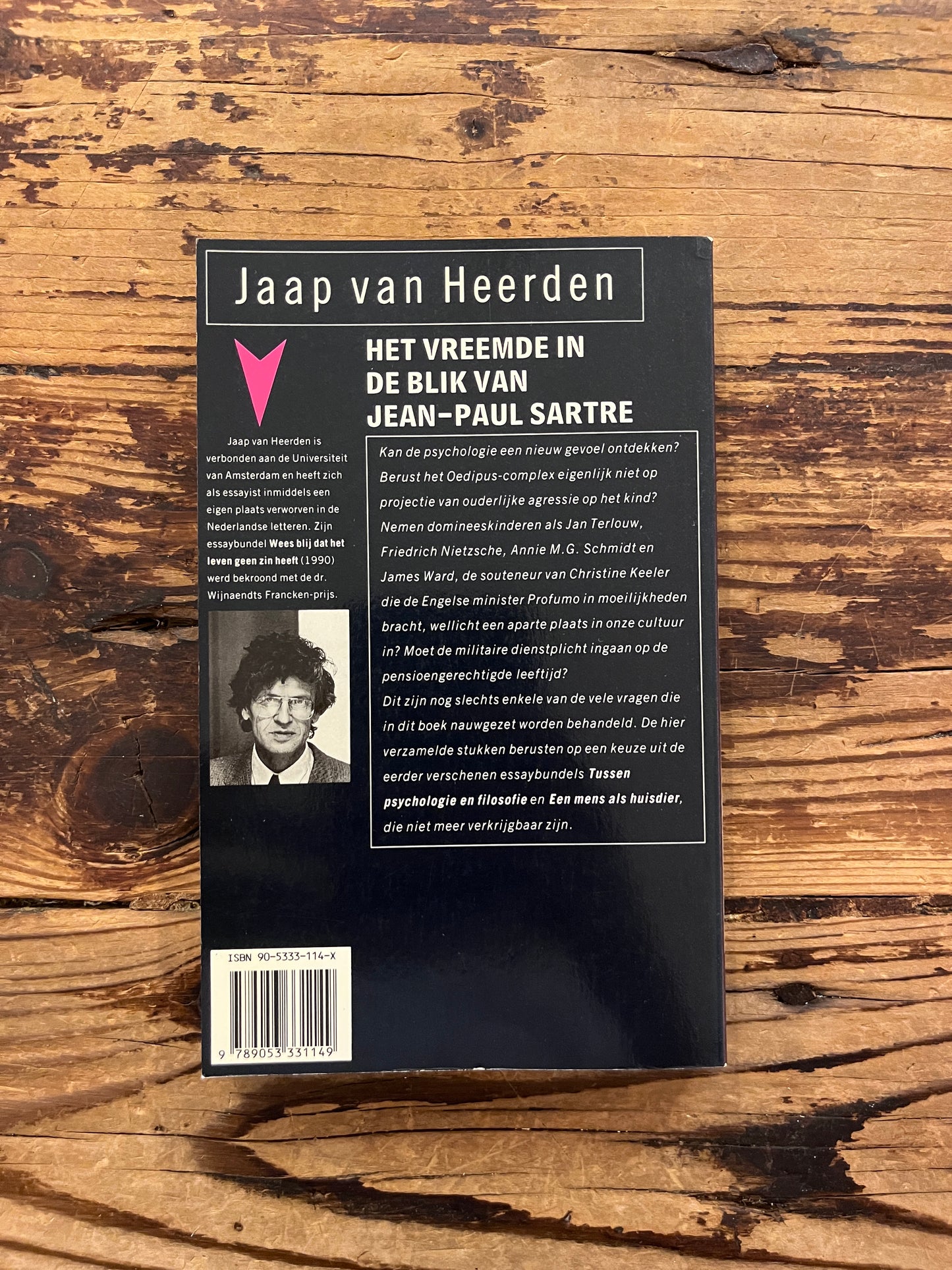 foto van de omslag van het boek "het vreemde in de blik van Jean-Paul Sartre" op houten achtergrond