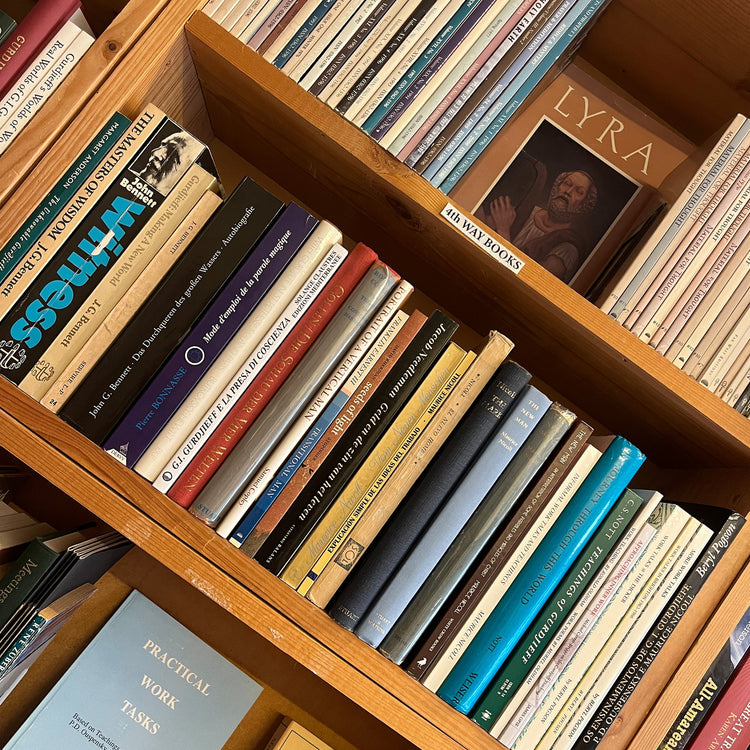 a sideways photo of a bookcase displaying a collection of books about the fourth way