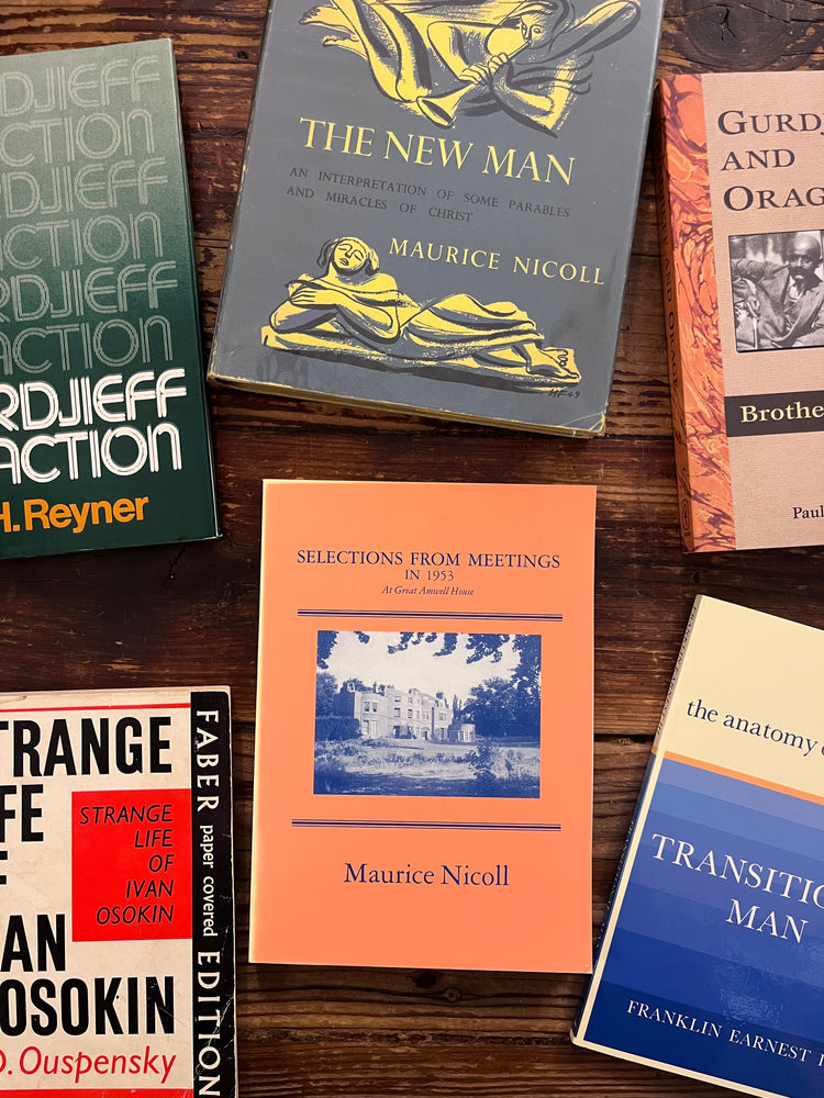 several 4th way books spread on a wooden table. Books with titles such as 'the new man' by Maurice Nicoll and 'Gurdjieff in Action ' by J.H. Reyner 