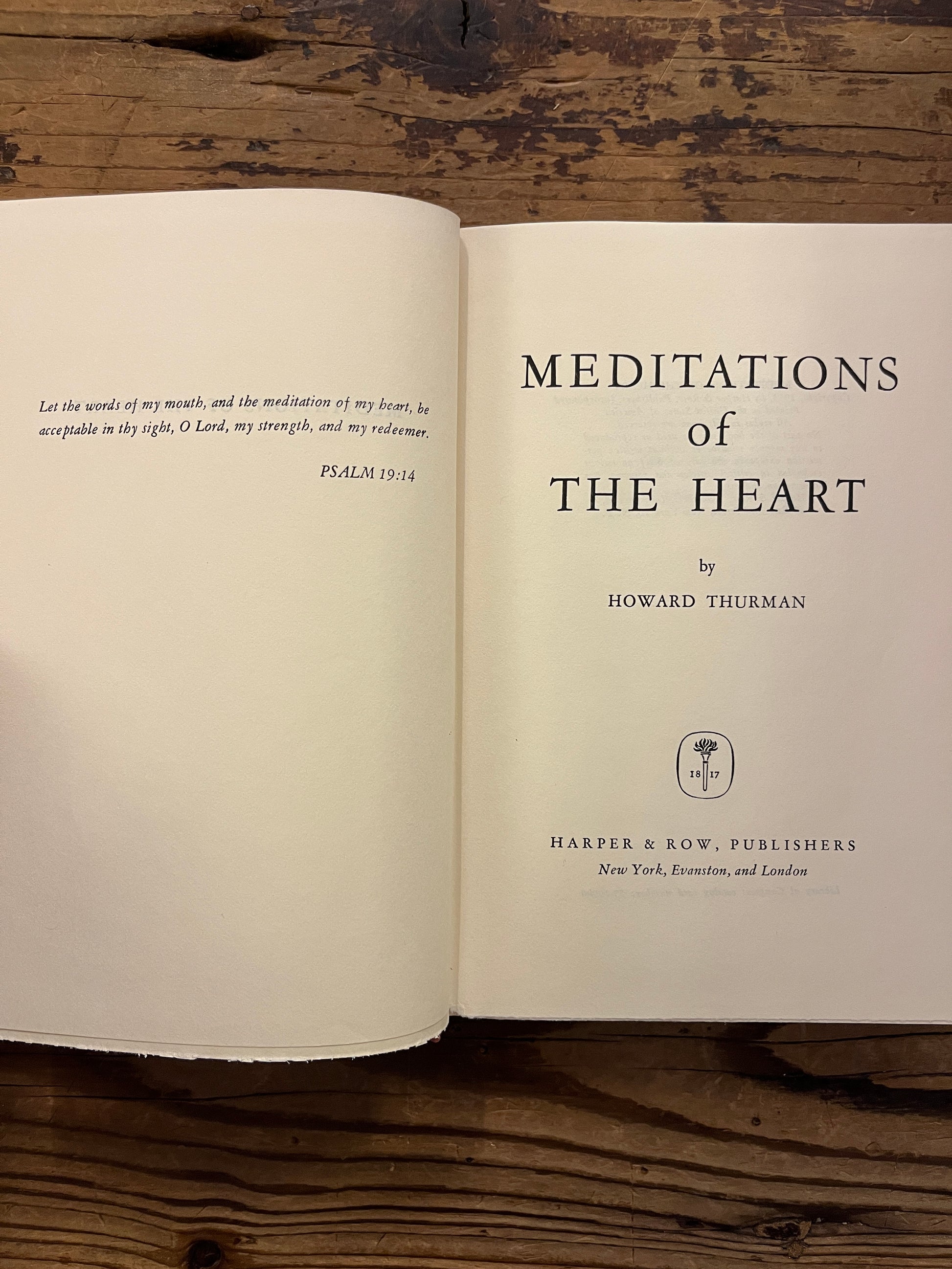 Open book titled 'Meditations of the Heart' by Howard Thurman on a wooden surface