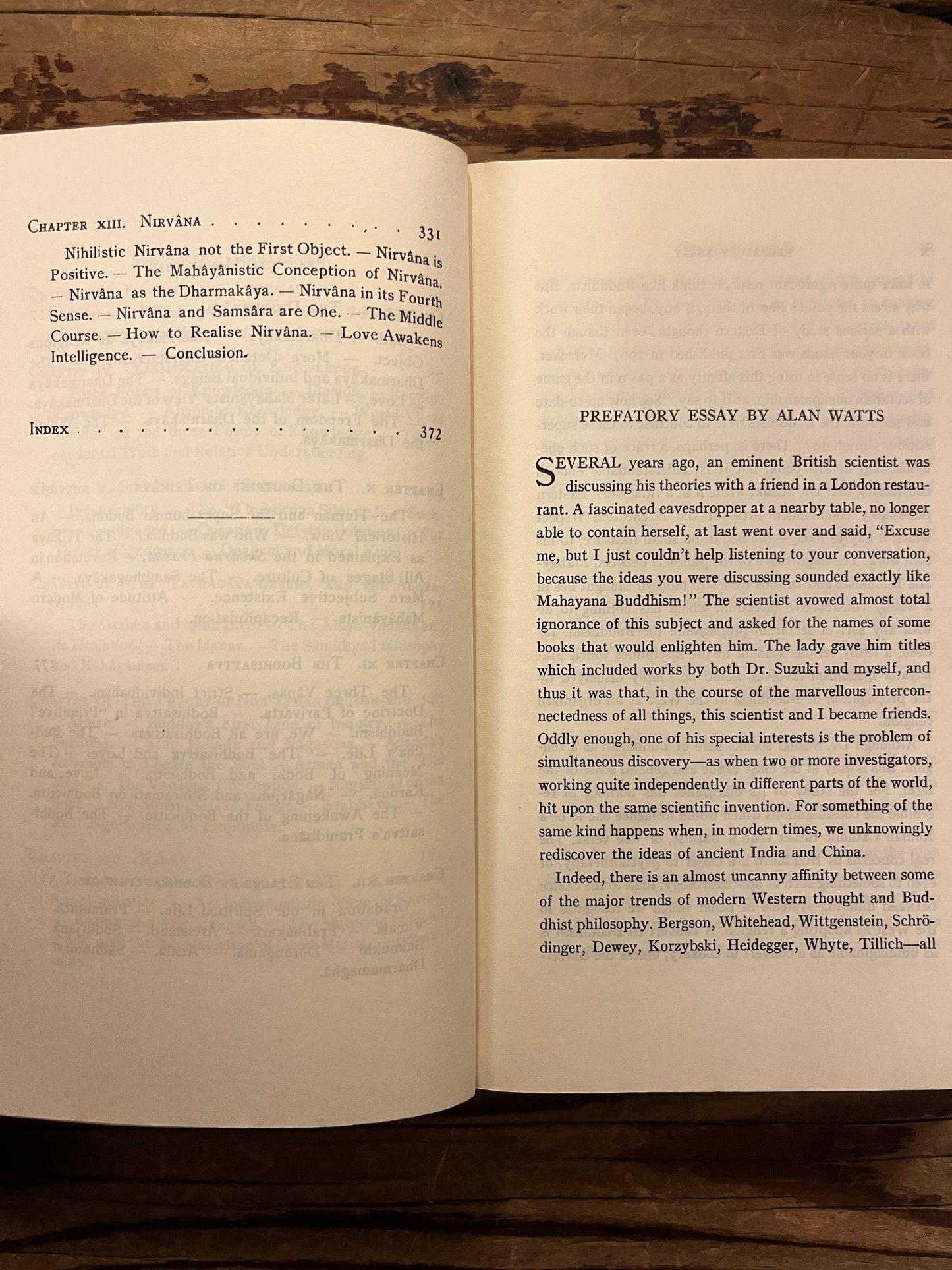 Open book titled 'Outlines of Mahayana Buddhism' by D.T. Suzuki on a wooden surface