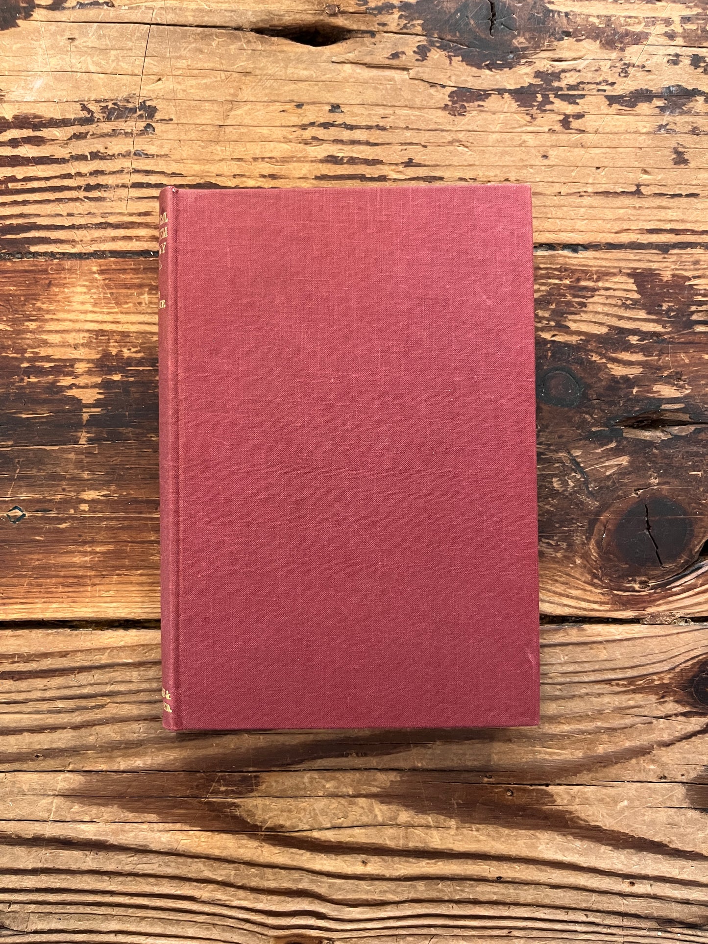 Front cloth cover of a rare book with the title 'practical occultism' by Dion Fortune on a wooden surface 
