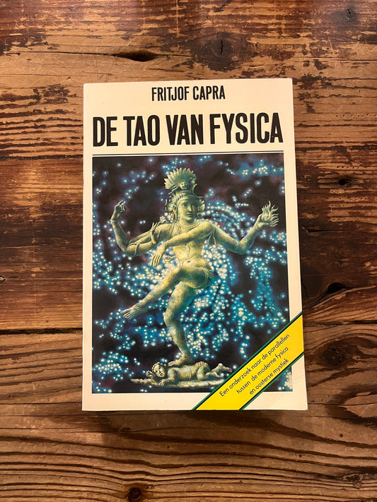Boek met de titel 'de Tao van Fisica' door Fritjof Capra op een houten achtergrond 