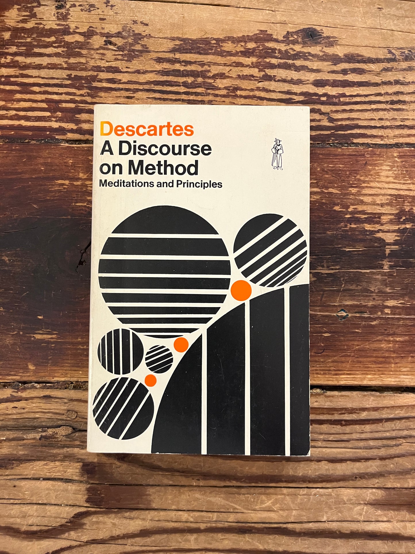 photo of the cover of the book "A discourse on method" on wooden baclground