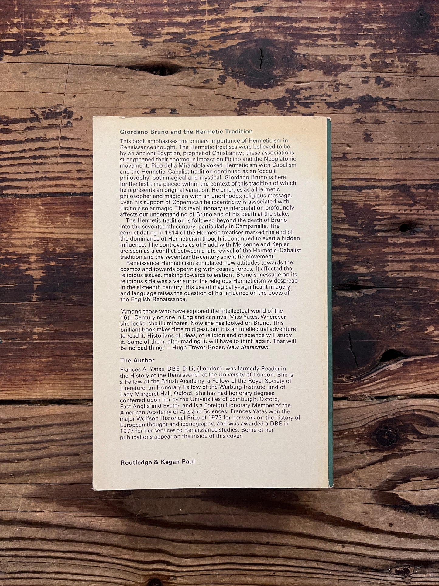 Back cover of a book titled 'Giordano Bruno and the Hermetic Tradition' by Frances A. Yates lying on a wooden surface
