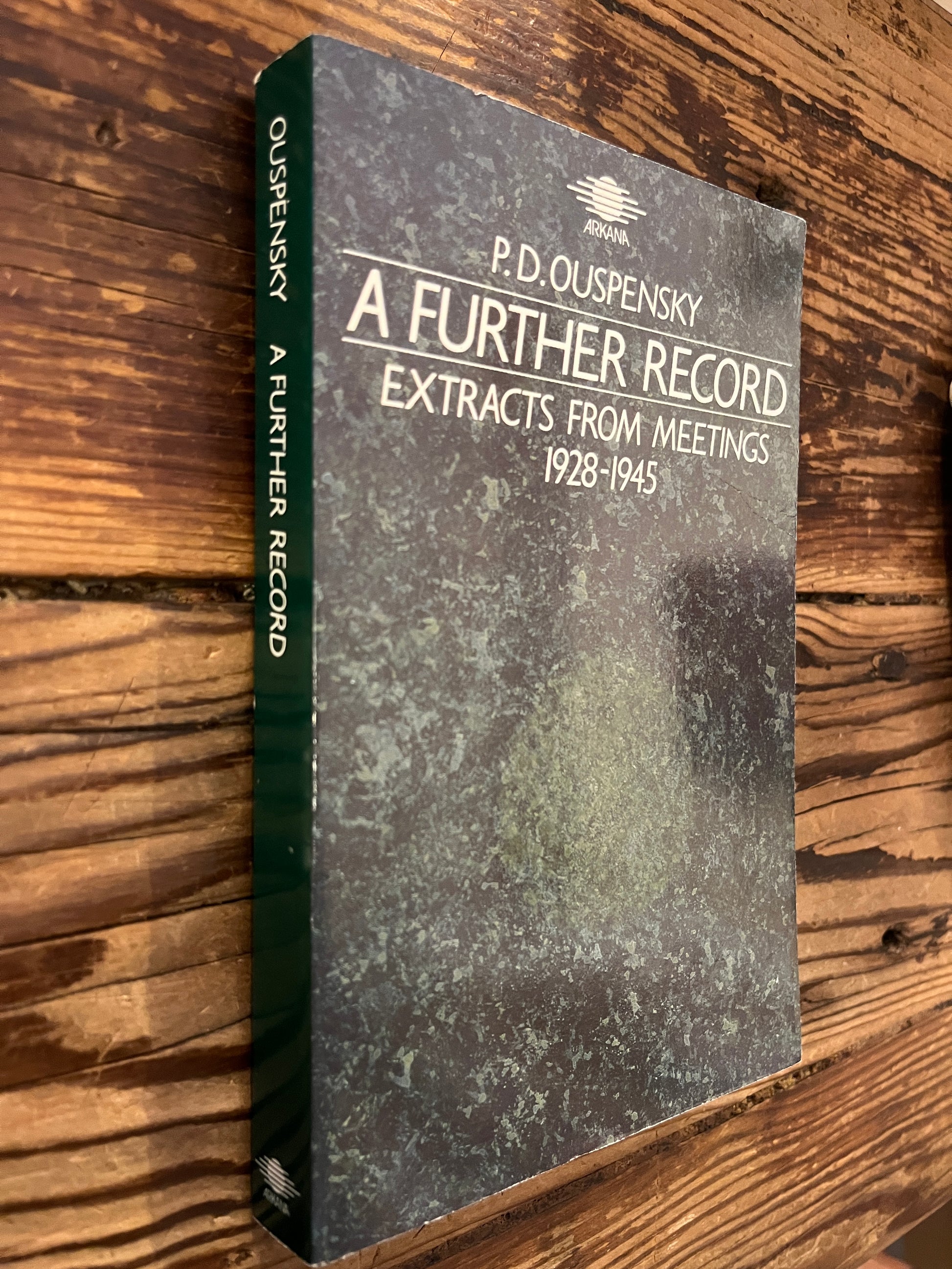 book titled 'a further record' by P.D. Ouspensky on a wooden surface 