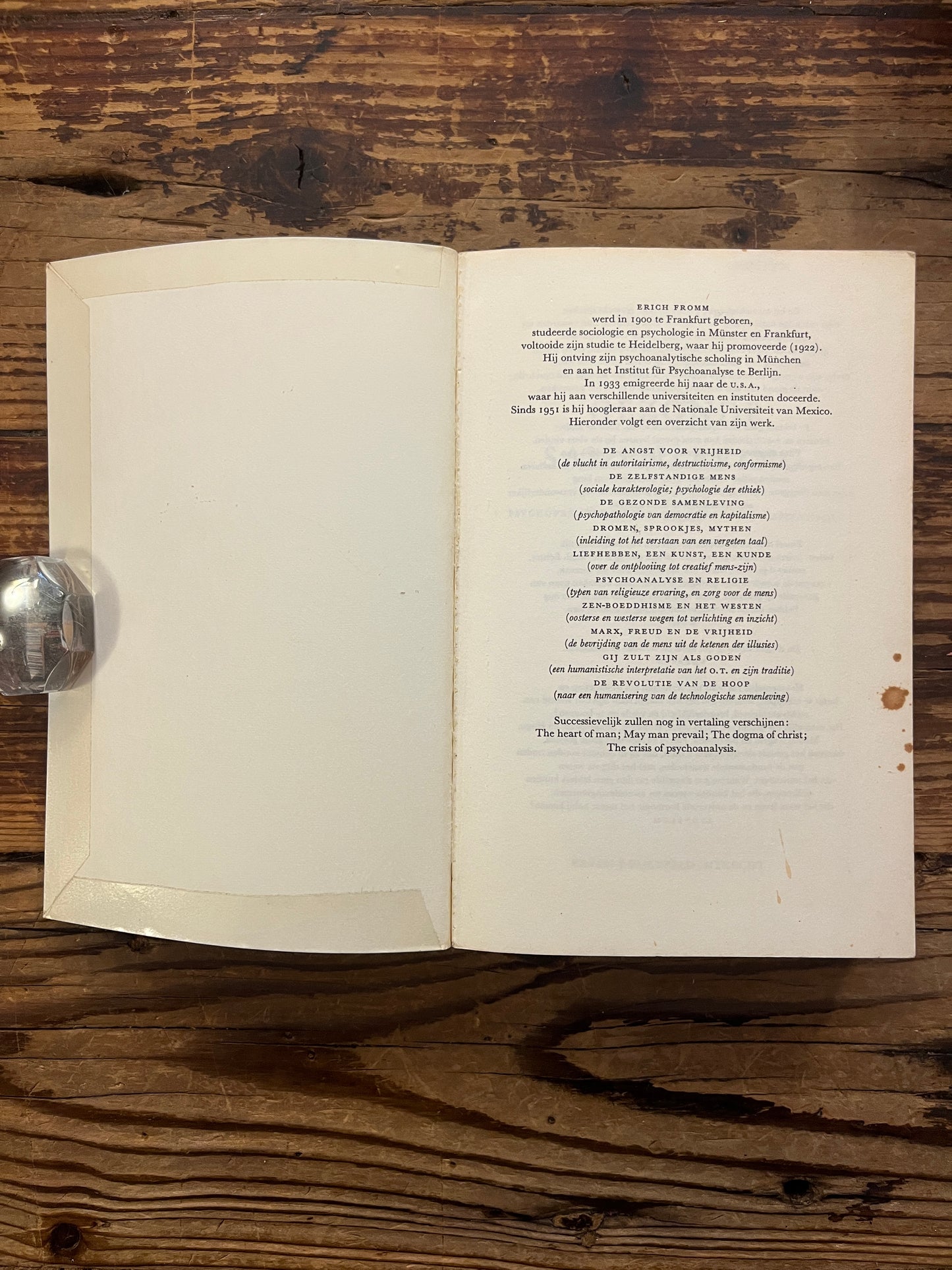 Open boek met de titel 'De gezonde samenleving' door Erich Fromm op een houten achtergrond 