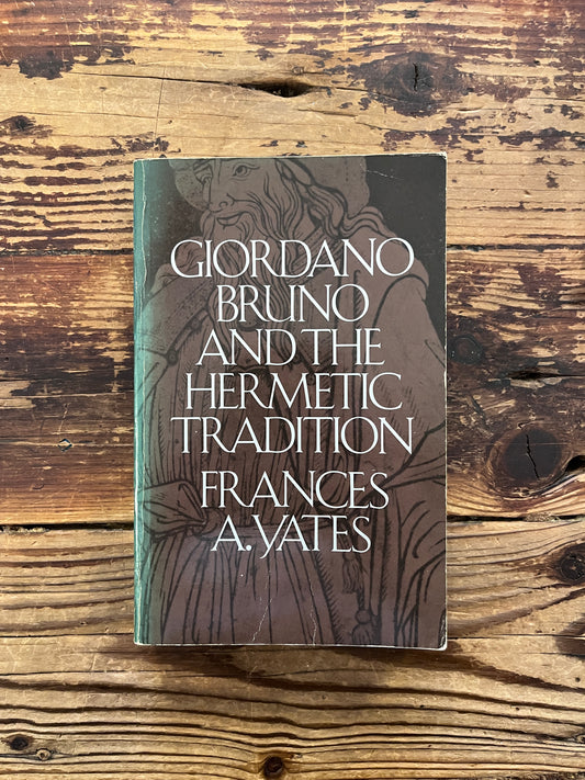 Front cover of a book titled 'Giordano Bruno and the Hermetic Tradition' by Frances A. Yates lying on a wooden surface