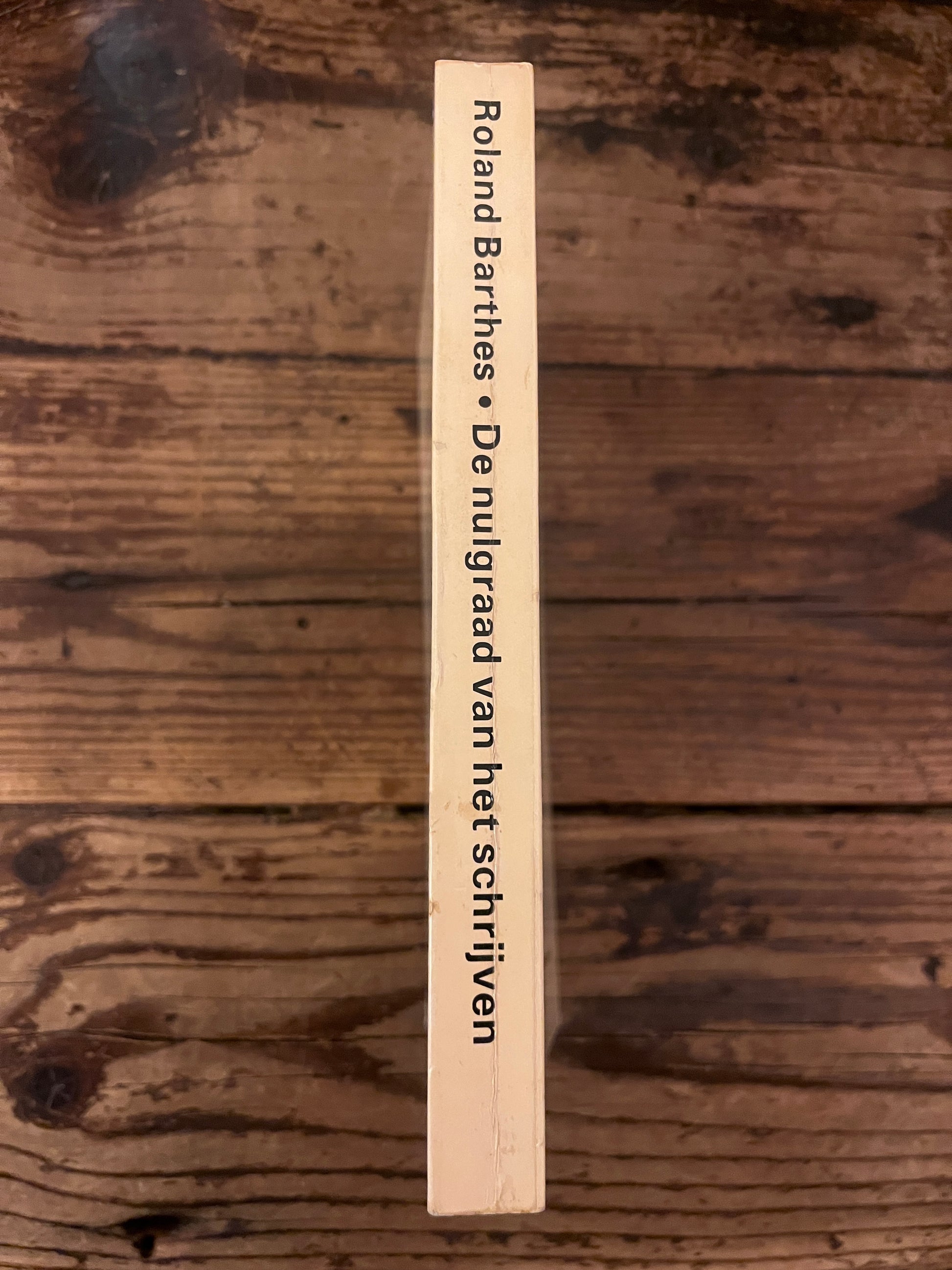 photo of the spine of the book "de nulgraad van het schrijven" on a wooden background