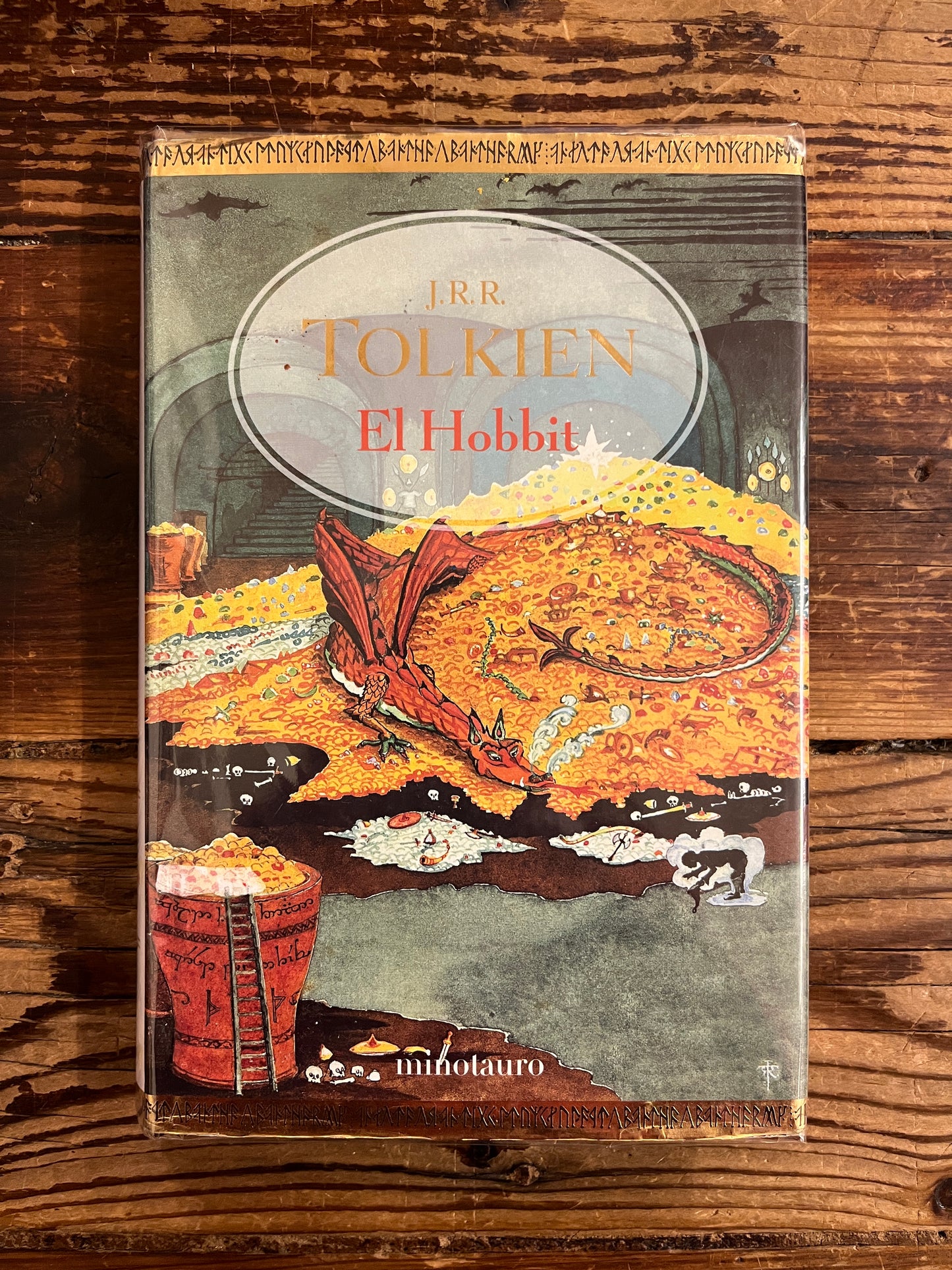 Book cover of 'The Hobbit' by J.R.R. Tolkien on a wooden surface