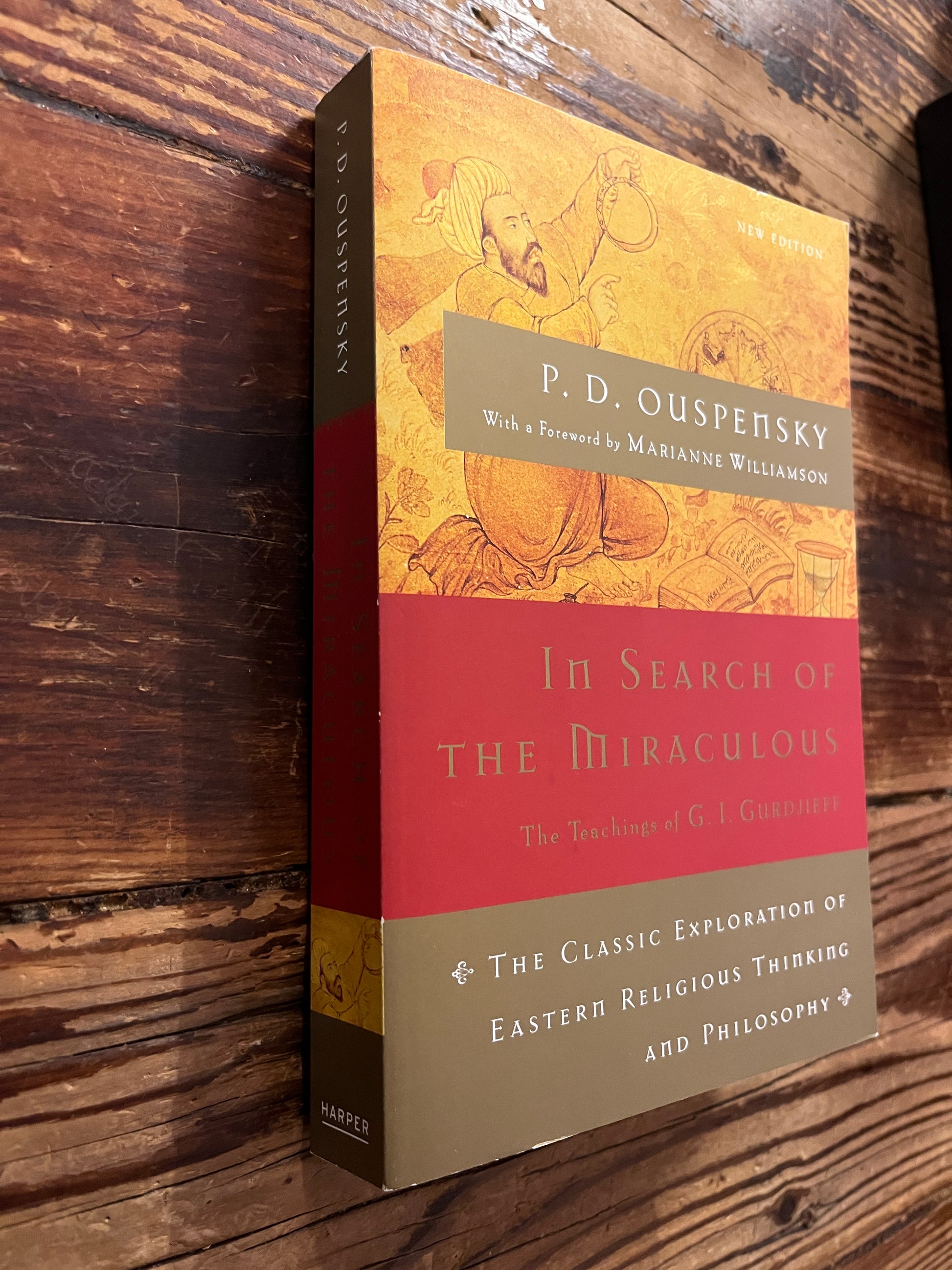 book titled 'In Search of the Miraculous' by P.D. Ouspensky on a wooden surface