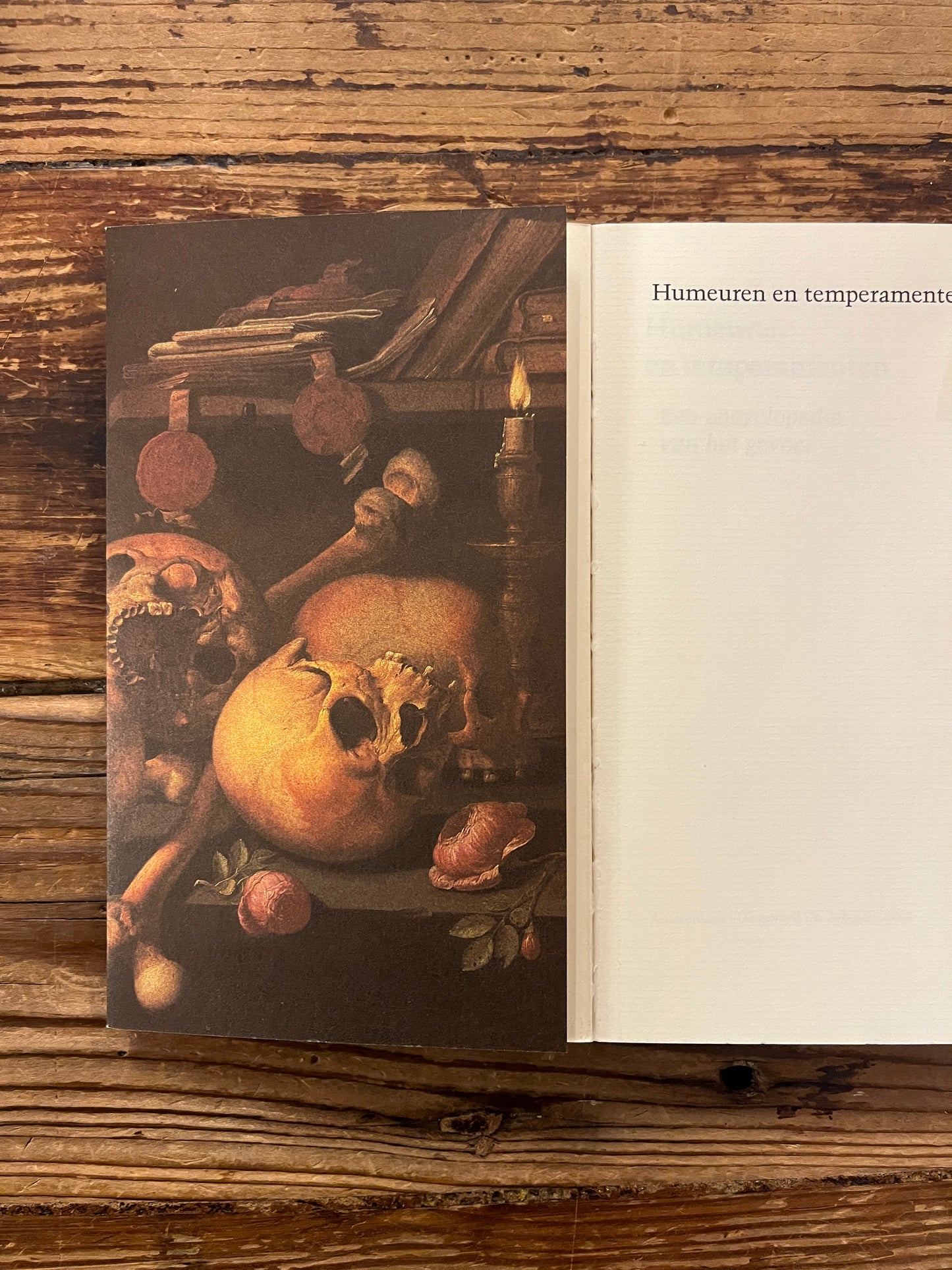 Open boek met de titel 'humeuren & temperamenten' door Gerrit Komrij op een houten achtergrond 