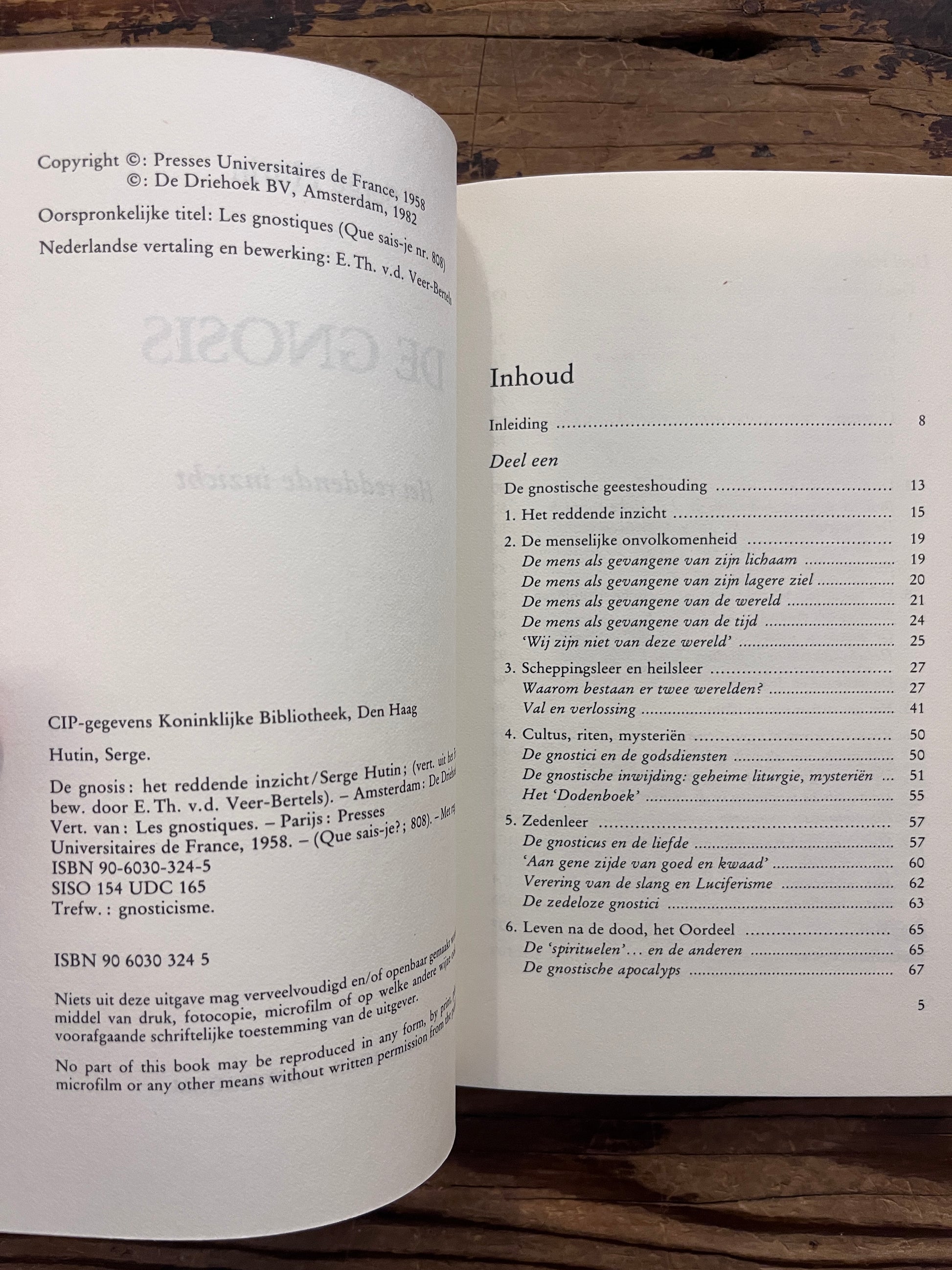 Open boek met de titel 'De Gnosis' door Serge Hutin op een houten achtergrond 