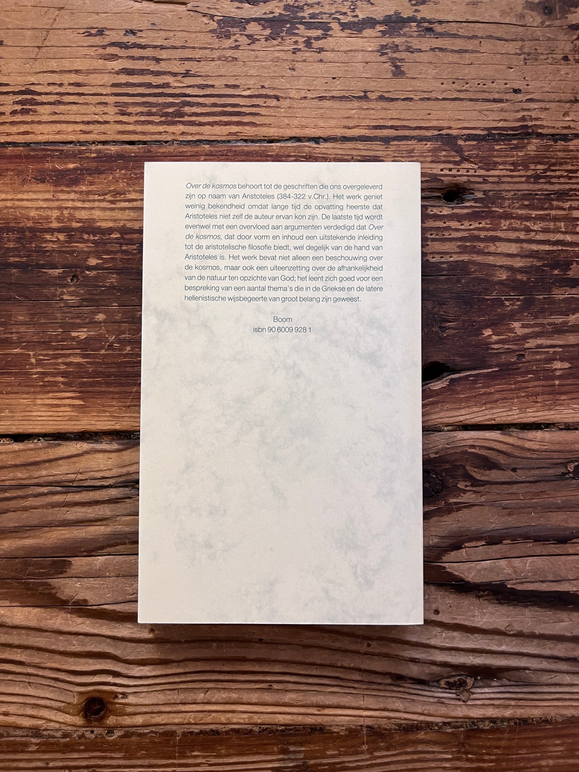 foto van de backcover van het boek "over de cosmos" op houten achtergrond