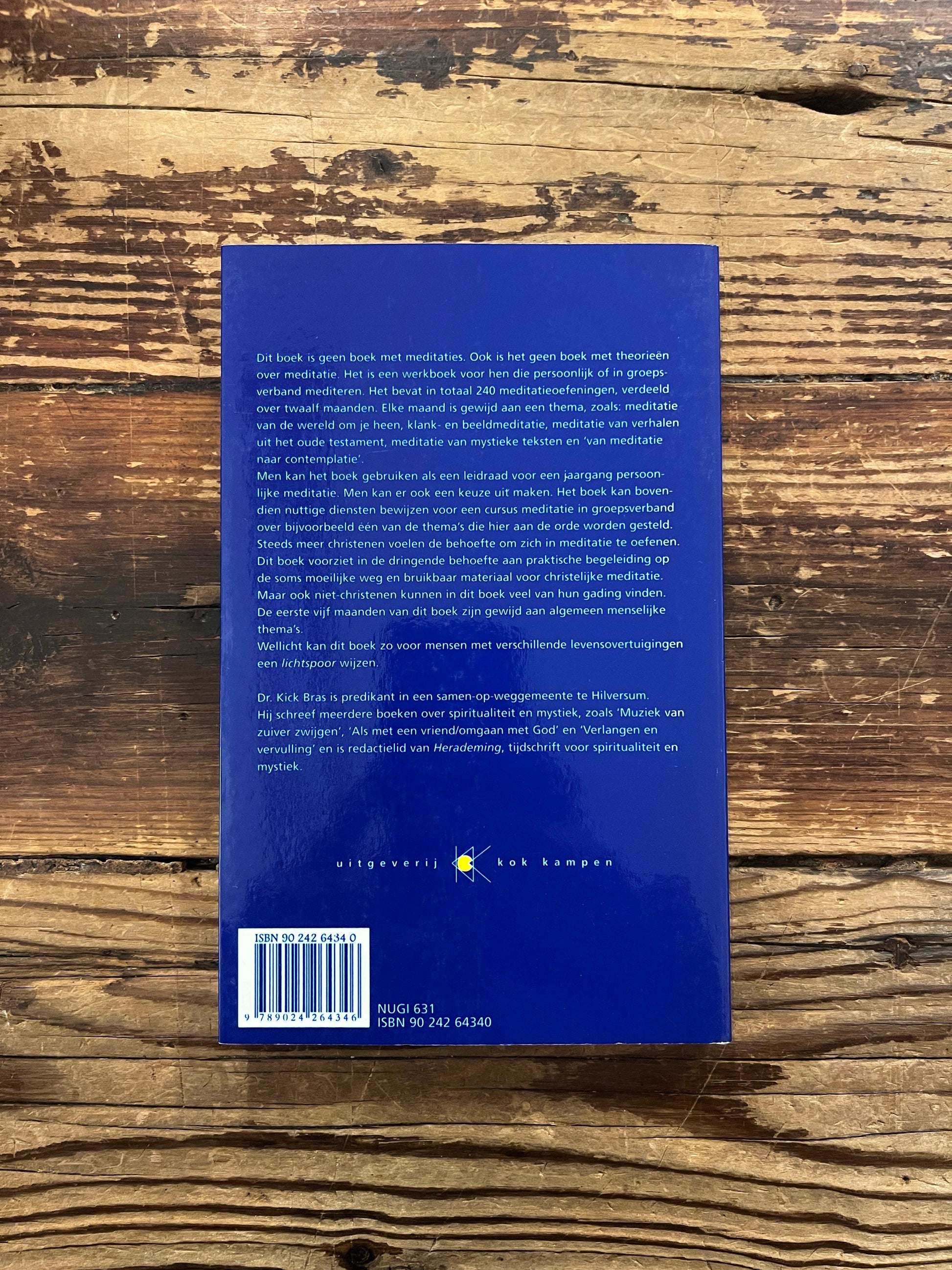 Achterkant van boek 'lichtspoor' door Kick Bras op een houten achtergrond 