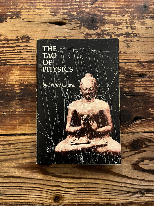 Front cover of book titled 'The Tao of Physics' by Fritjof Capra on a wooden surface