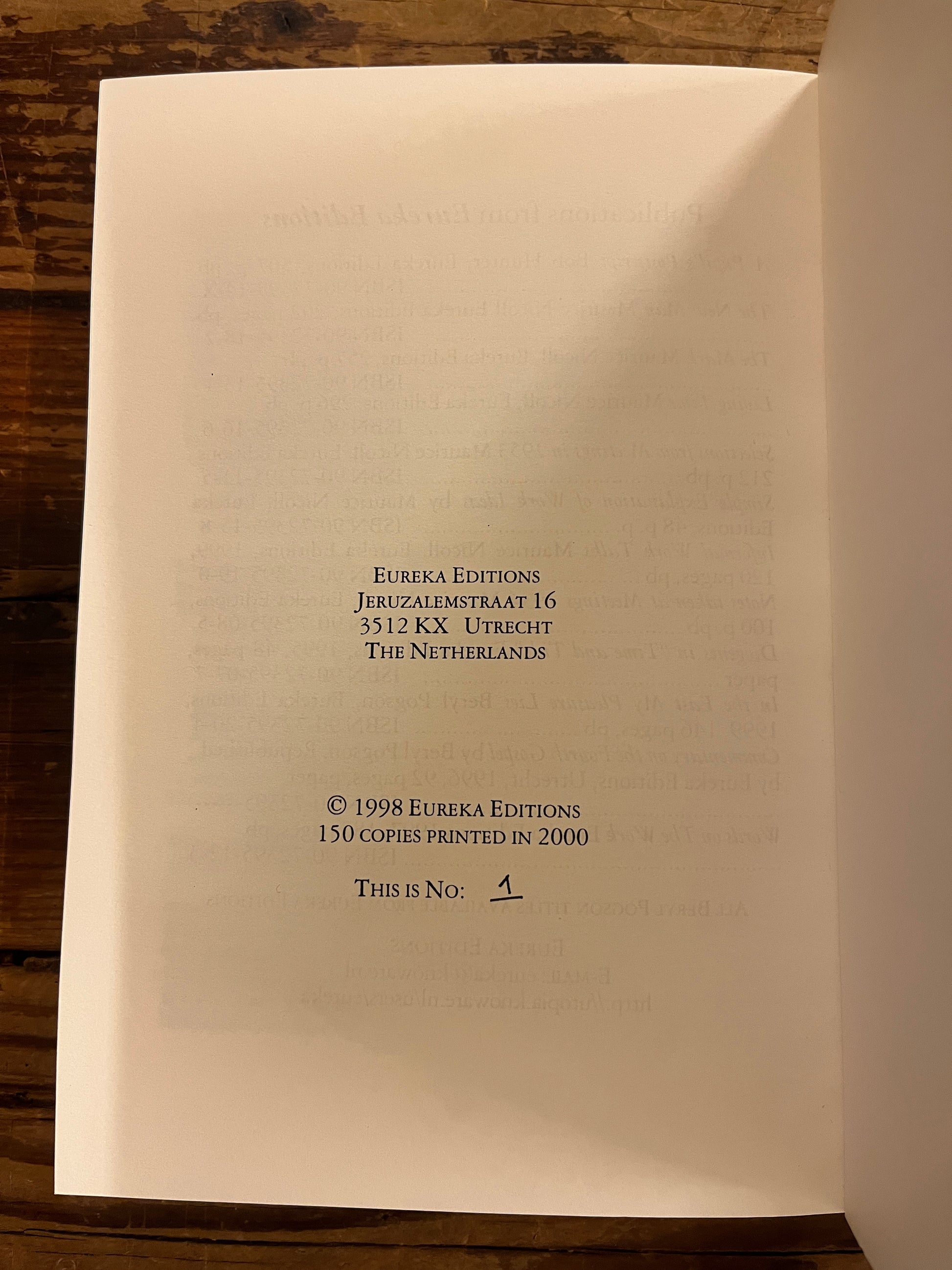 Last page of book titled 'living time' by Maurice Nicoll showing the hand written number 1/150 of the books printed in 2000 on wooden surface