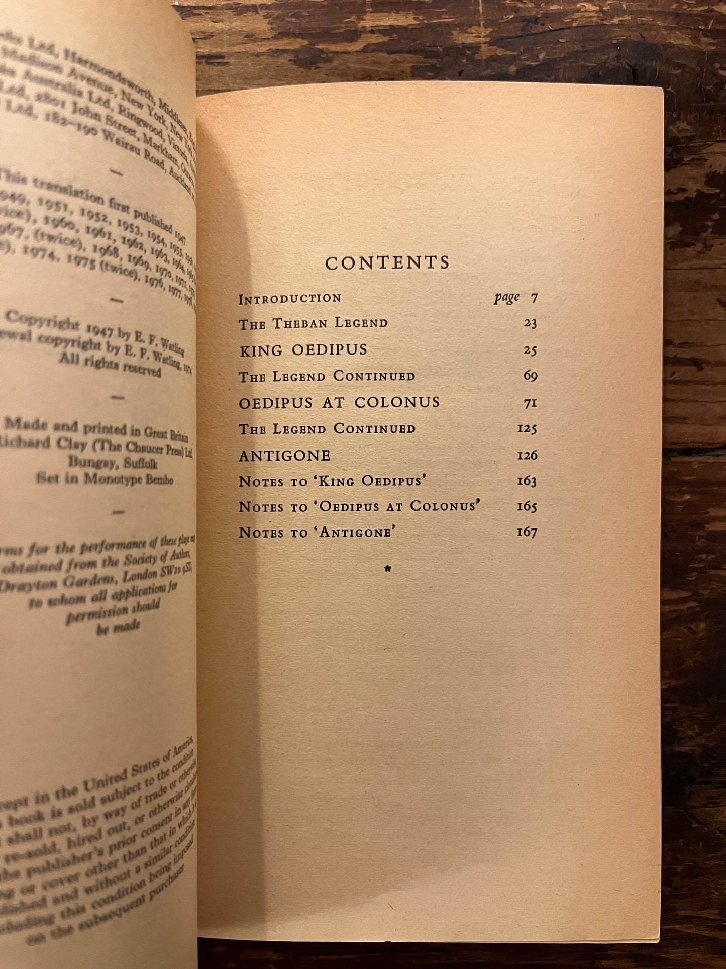 Open book titled 'The Theban Plays' by Sophocles on a wooden surface