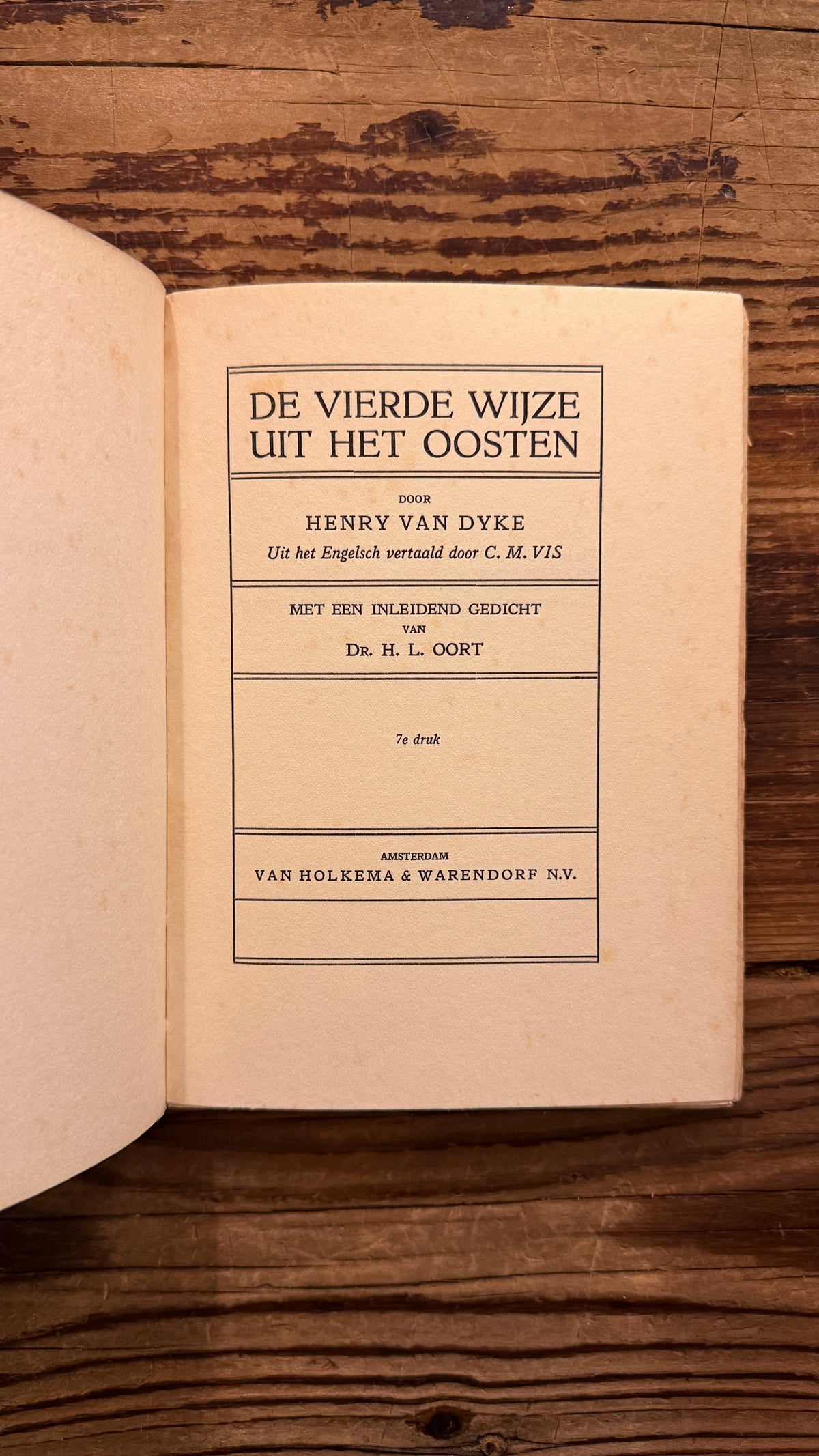 Titel pagina van een boek met de titel 'De Vierde Wijze uit het Oosten' door Henry van Dyke op een houten achtergrond