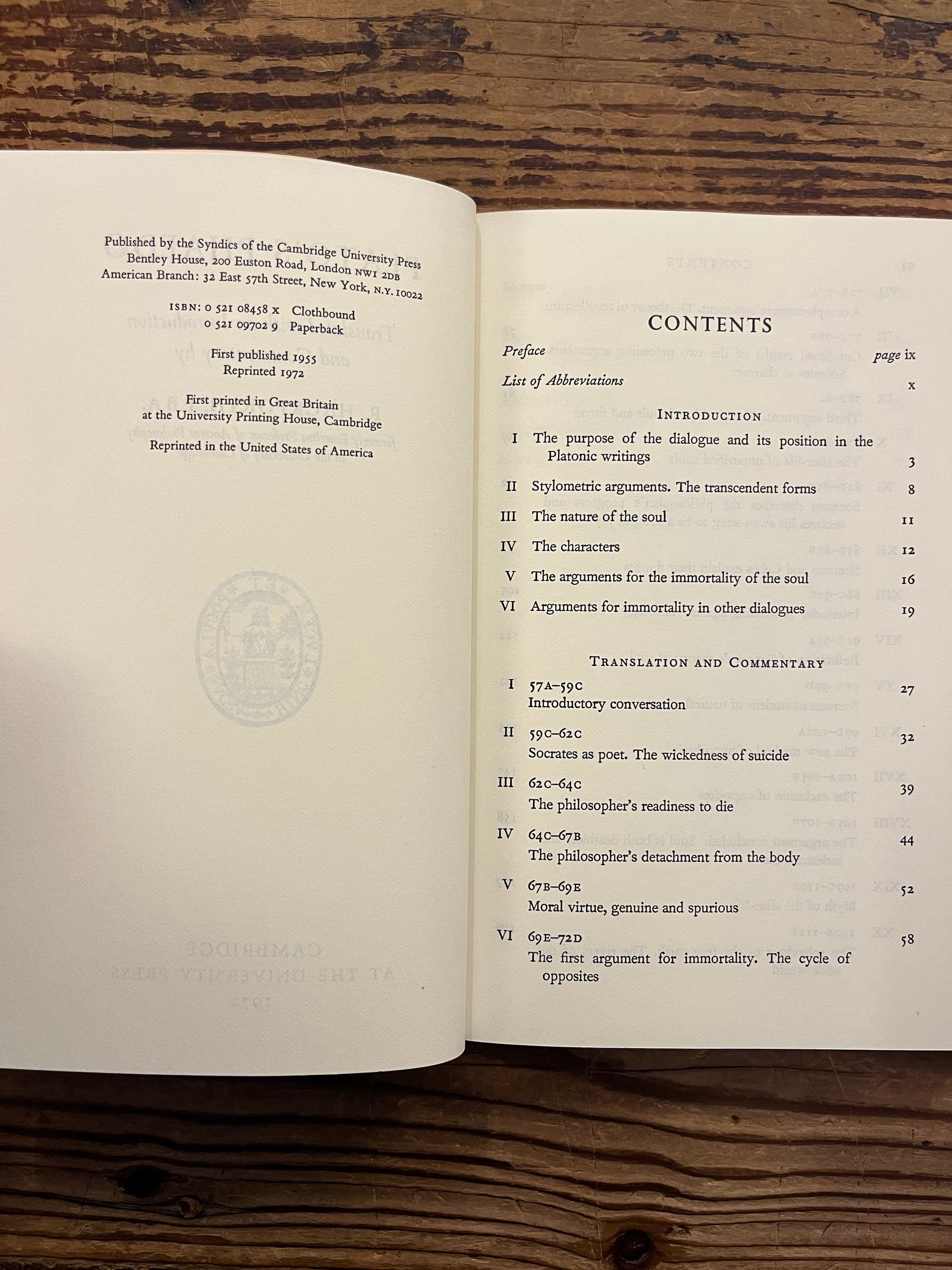 Open book titled 'Plato's Phaedo' translated with an introduction and commentary by R. Hackforth on a wooden surface