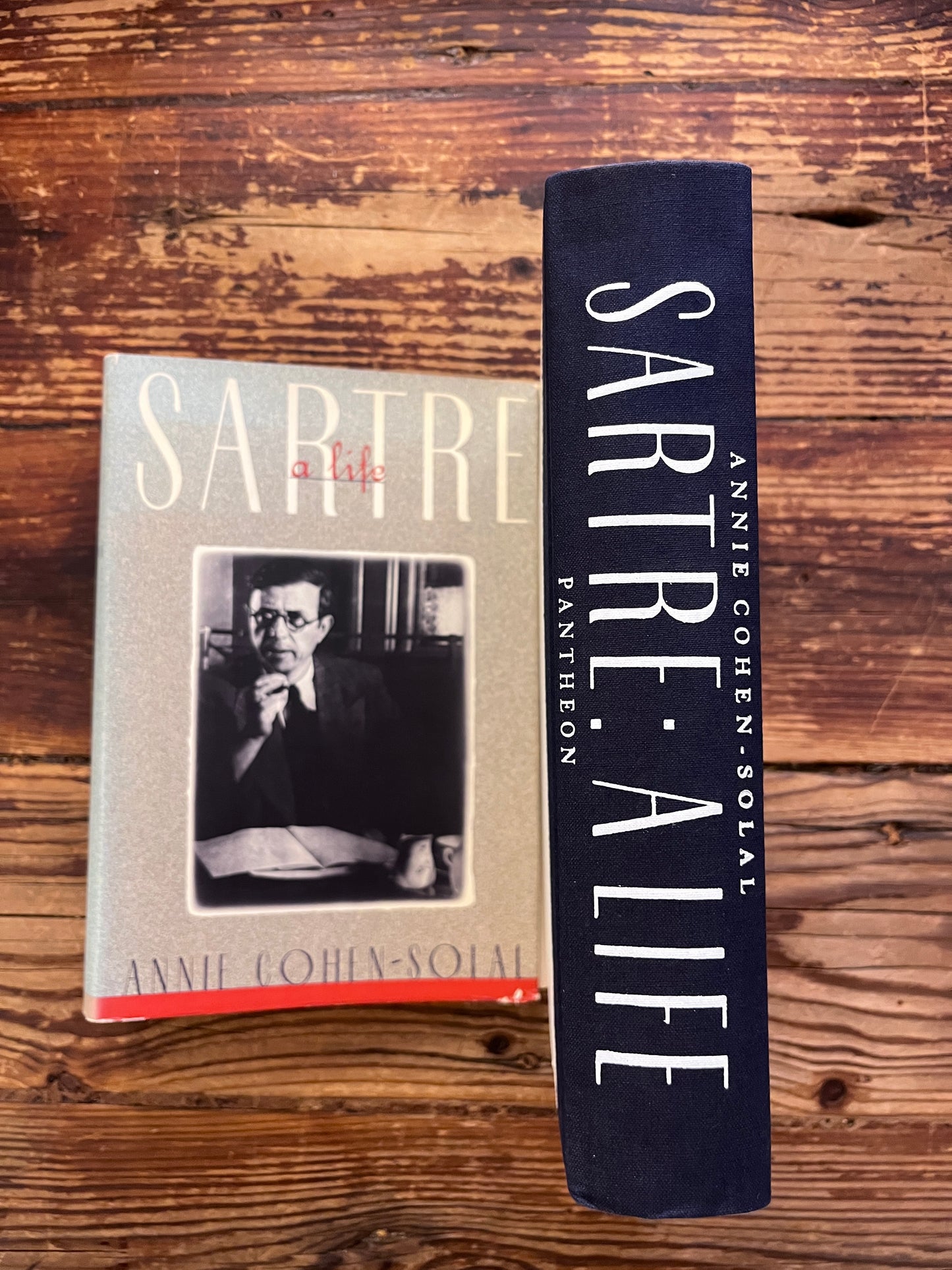 photo of the spine of the book without dust jacket "sartre"on a wooden background