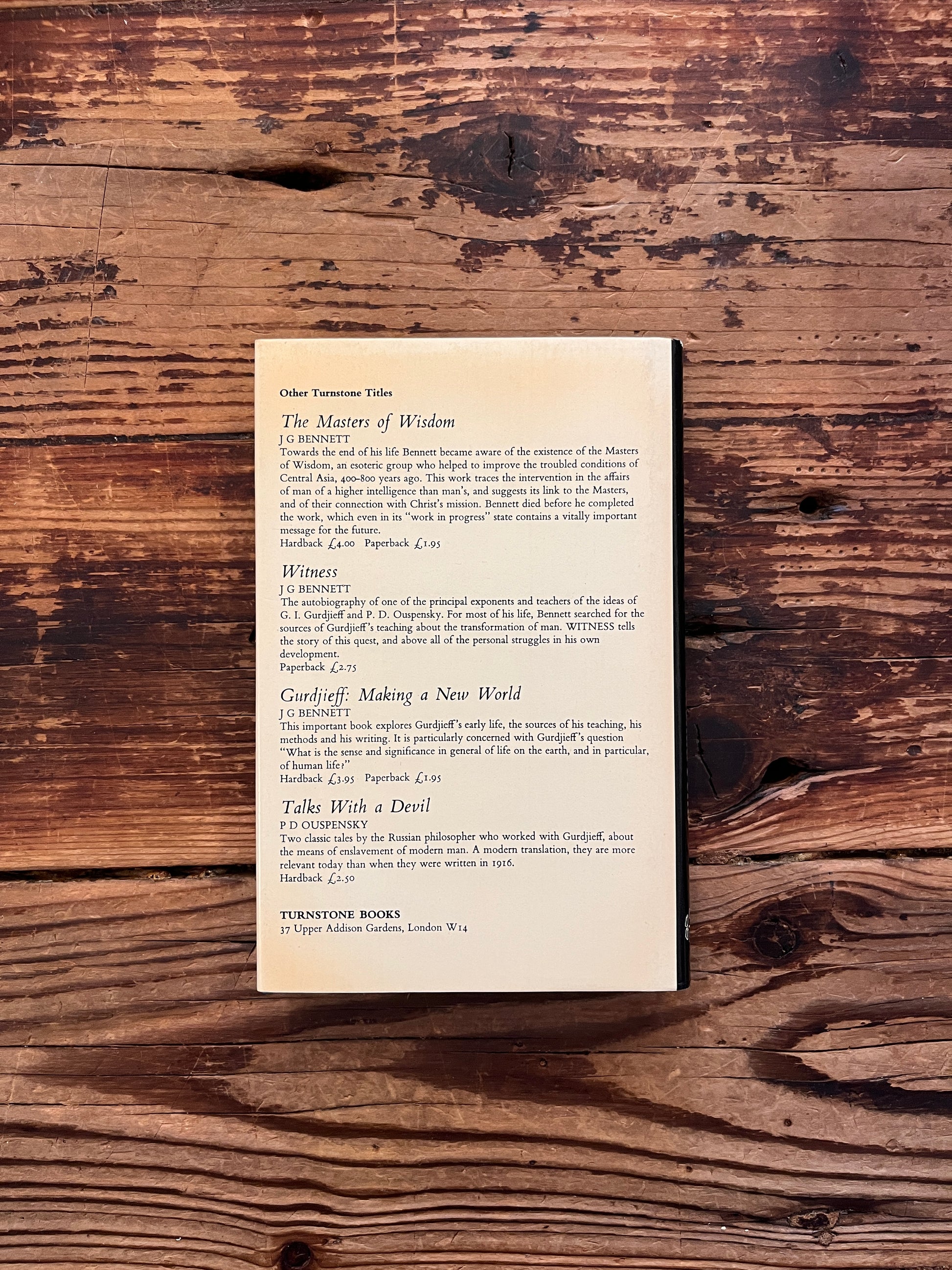 Open book with the title 'the Last Barrier,a sufi journey' by Reshad Feild on a wooden surface 