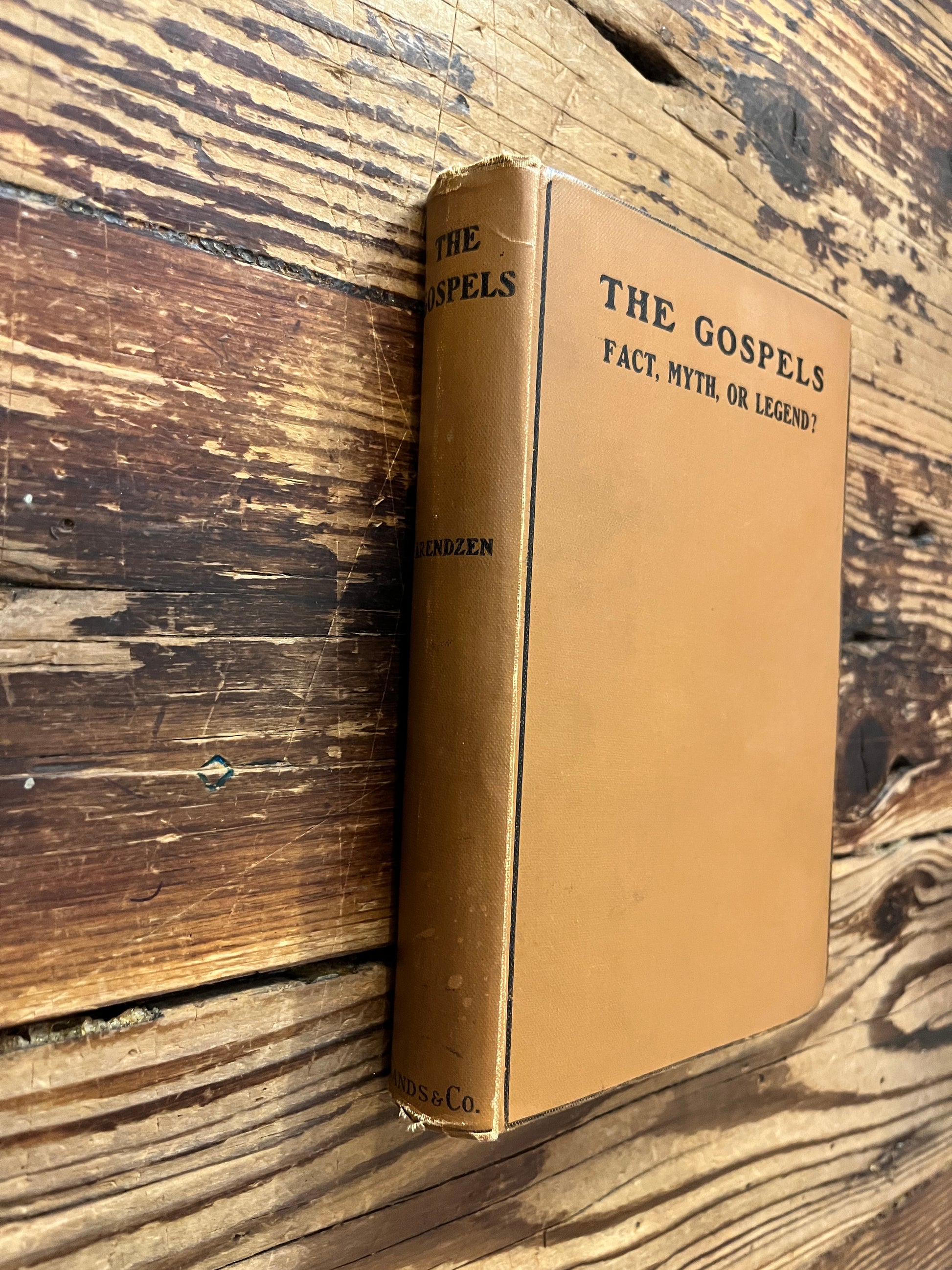 Front cover and spine of book with the title 'the gospels, fact, myth or legend ? by J.P. Arendzen Ph.D. on a wooden surface