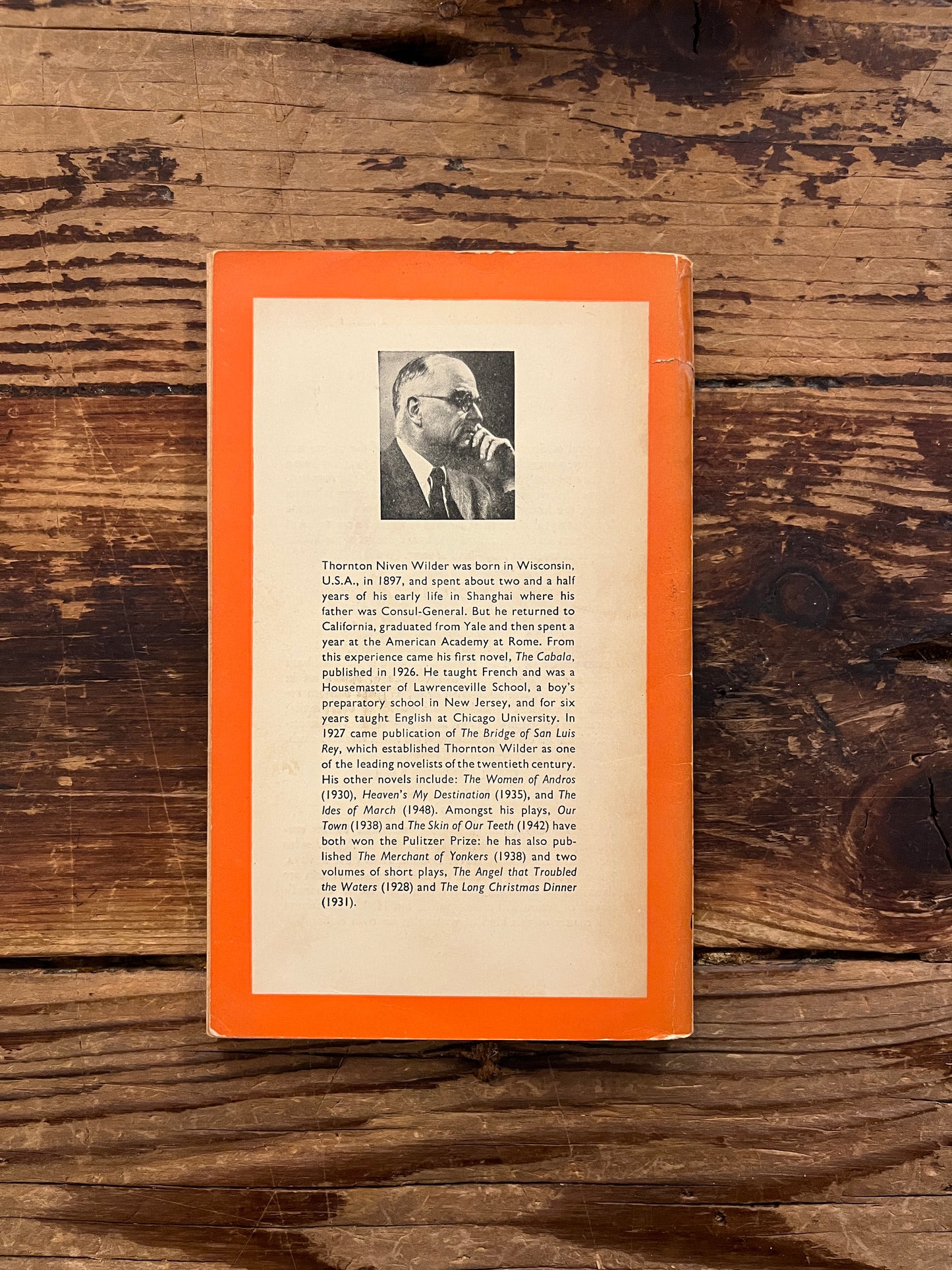 Back cover of book titled 'The Bridge of San Luis Rey' by Thornton Wilder on a wooden surface