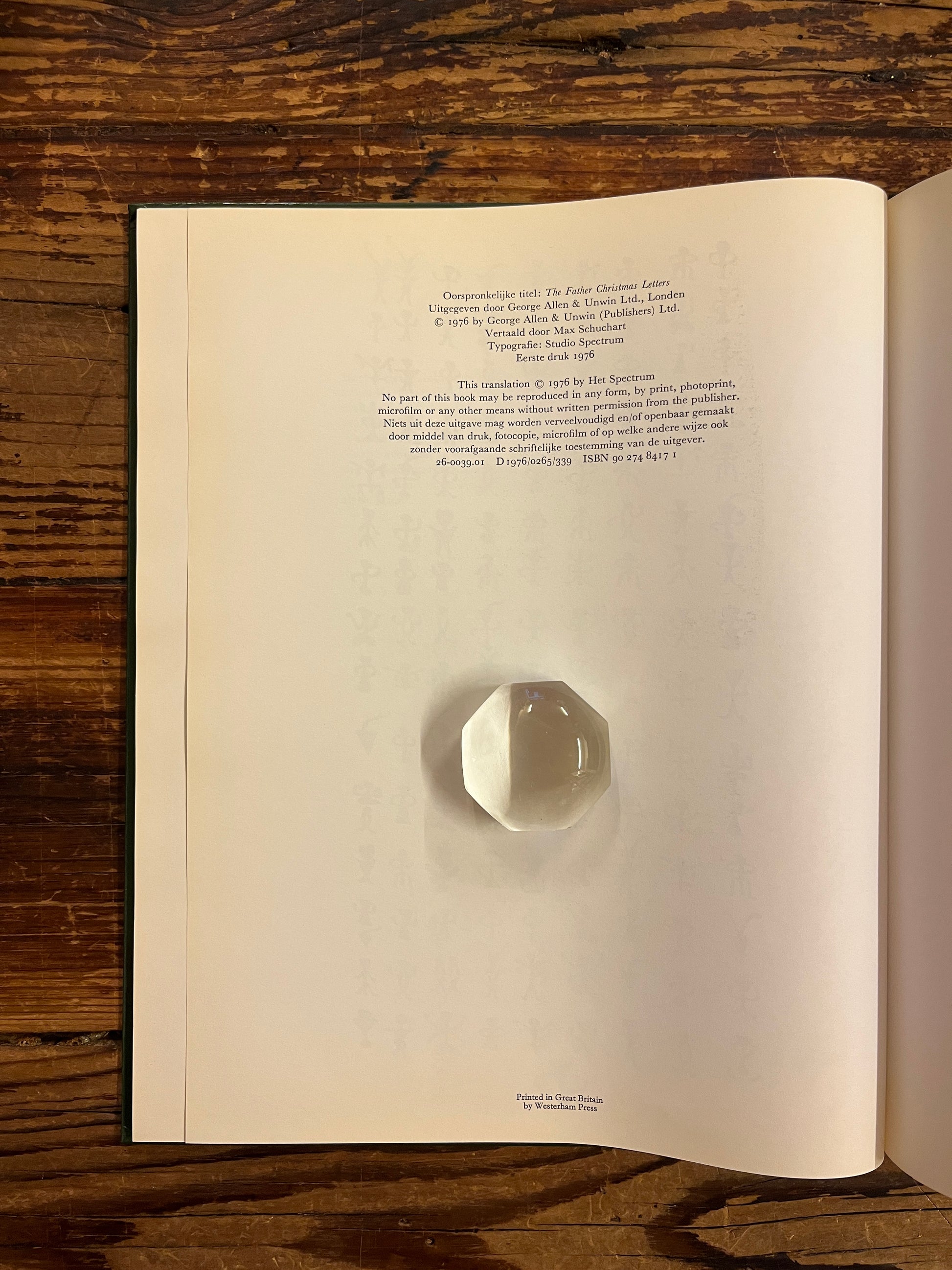 Open boek op pagina van uitgeverij details van boek 'brieven van de kerstman' door J. R. R. Tolkien op een houten achtergrond 