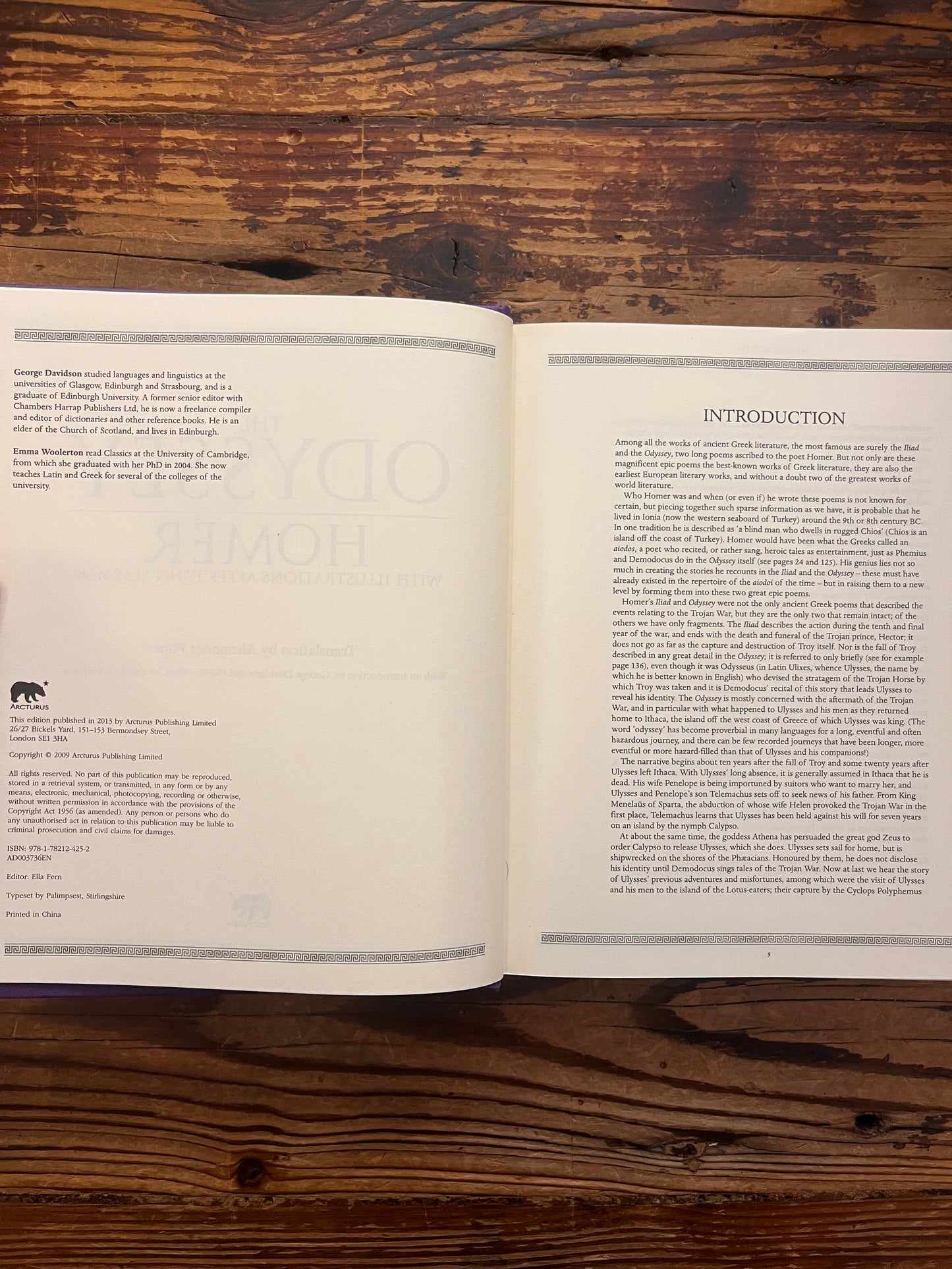 Open book titled 'The Odyssey' by Homer and translated by A. Pope on a wooden surface
