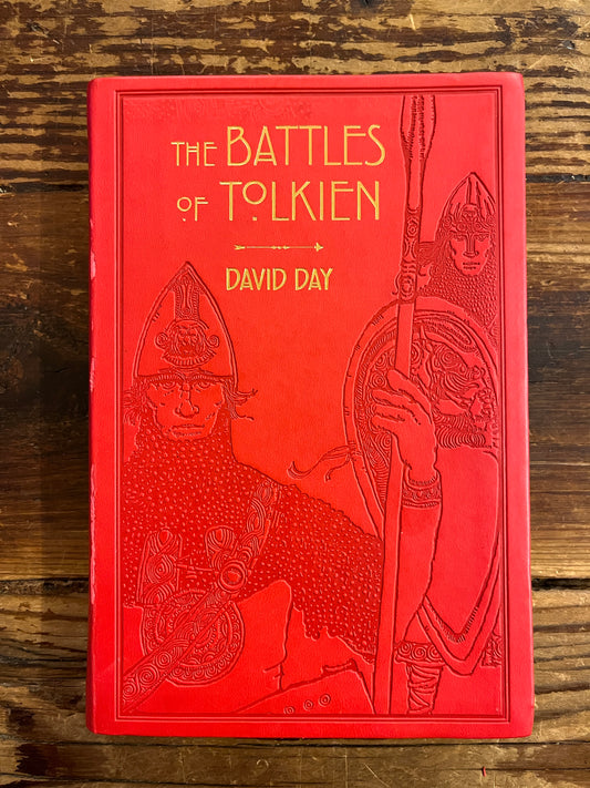 Front cover of book titled 'The Battles of Tolkien' by David Day on a wooden surface