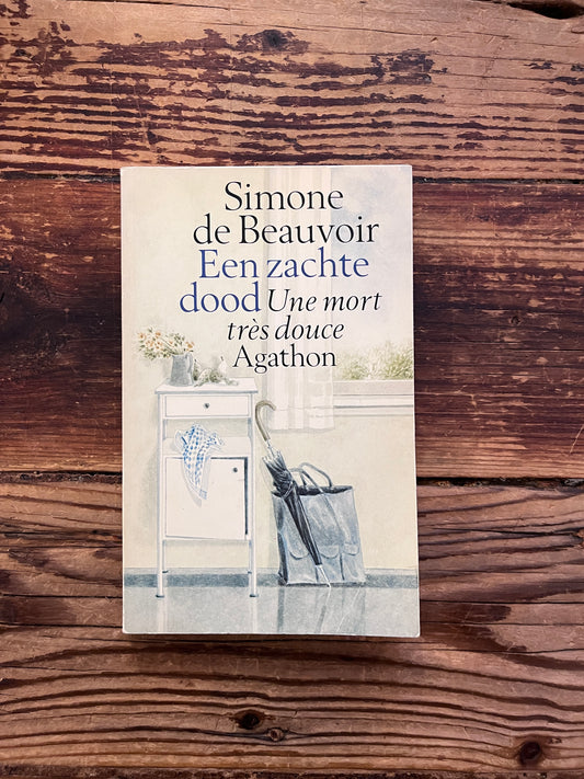 foto van de cover van het boek "een zachte dood"op houten achtergrond