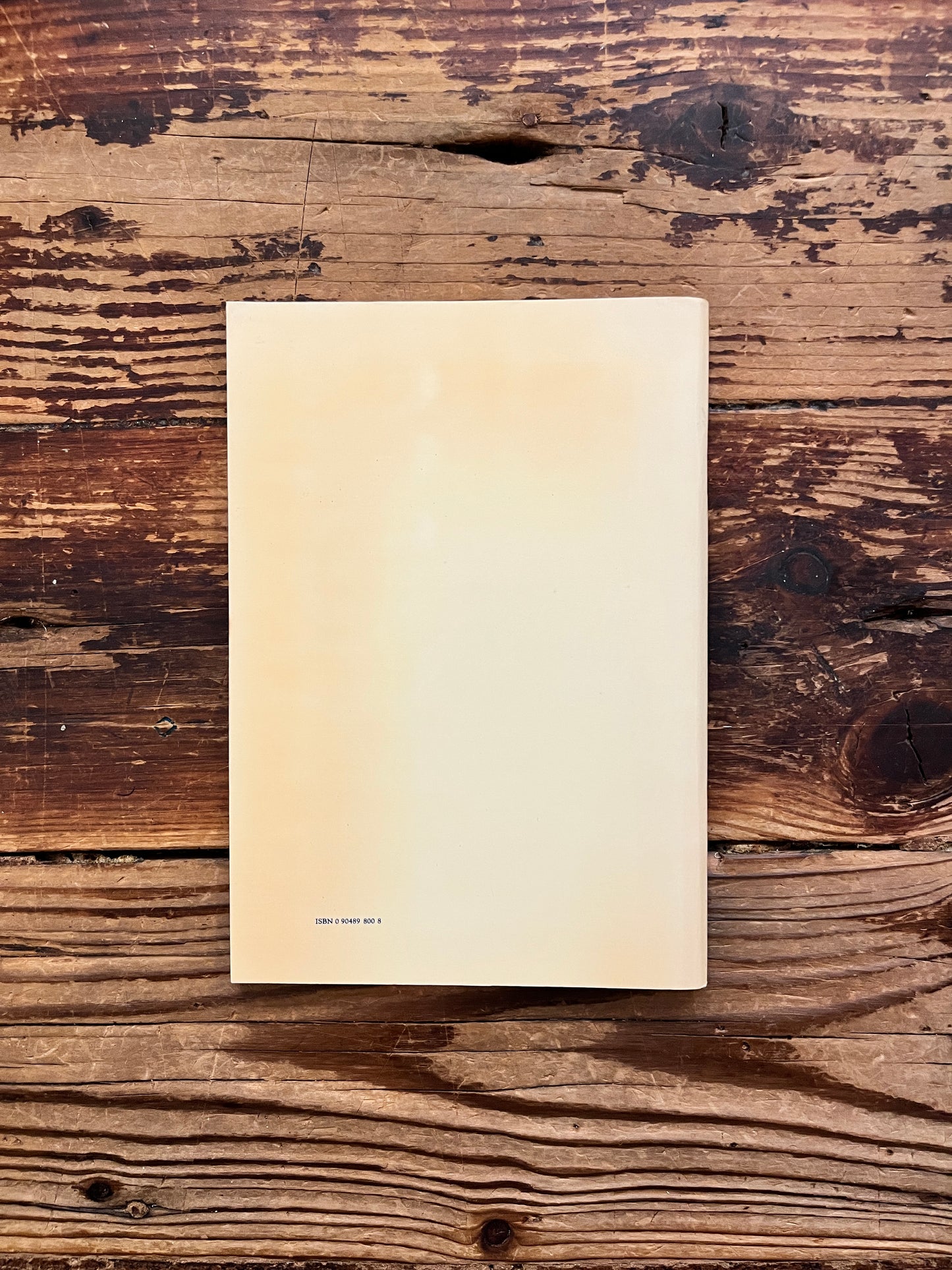 Back cover of a book titled 'Canterbury: the story of a cathedral' photographed on a rustic wooden surface.