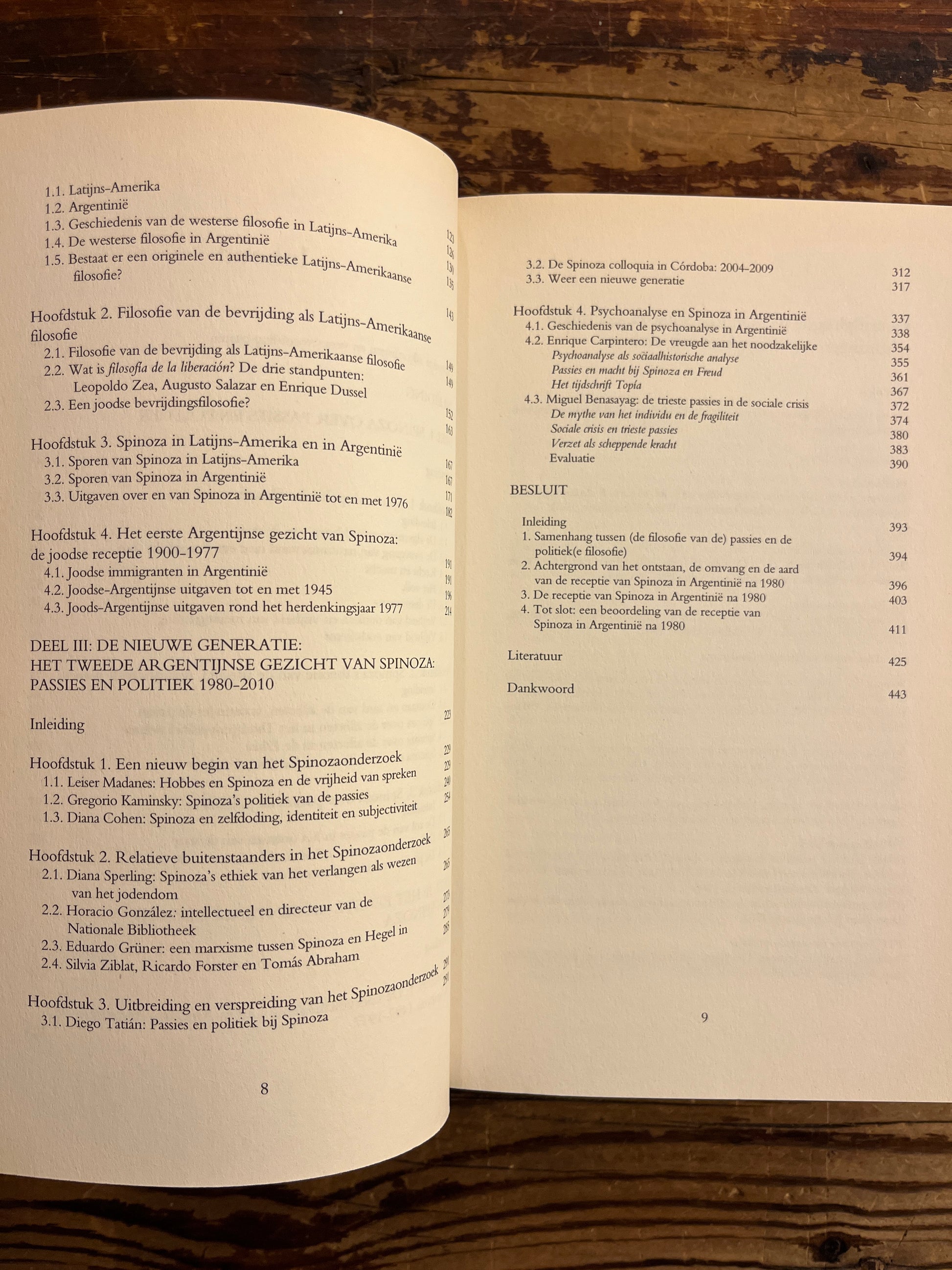 Open boek met de titel 'het Argentijnse gezicht van Spinoza' door Miriam van Reijen op een houten achtergrond 