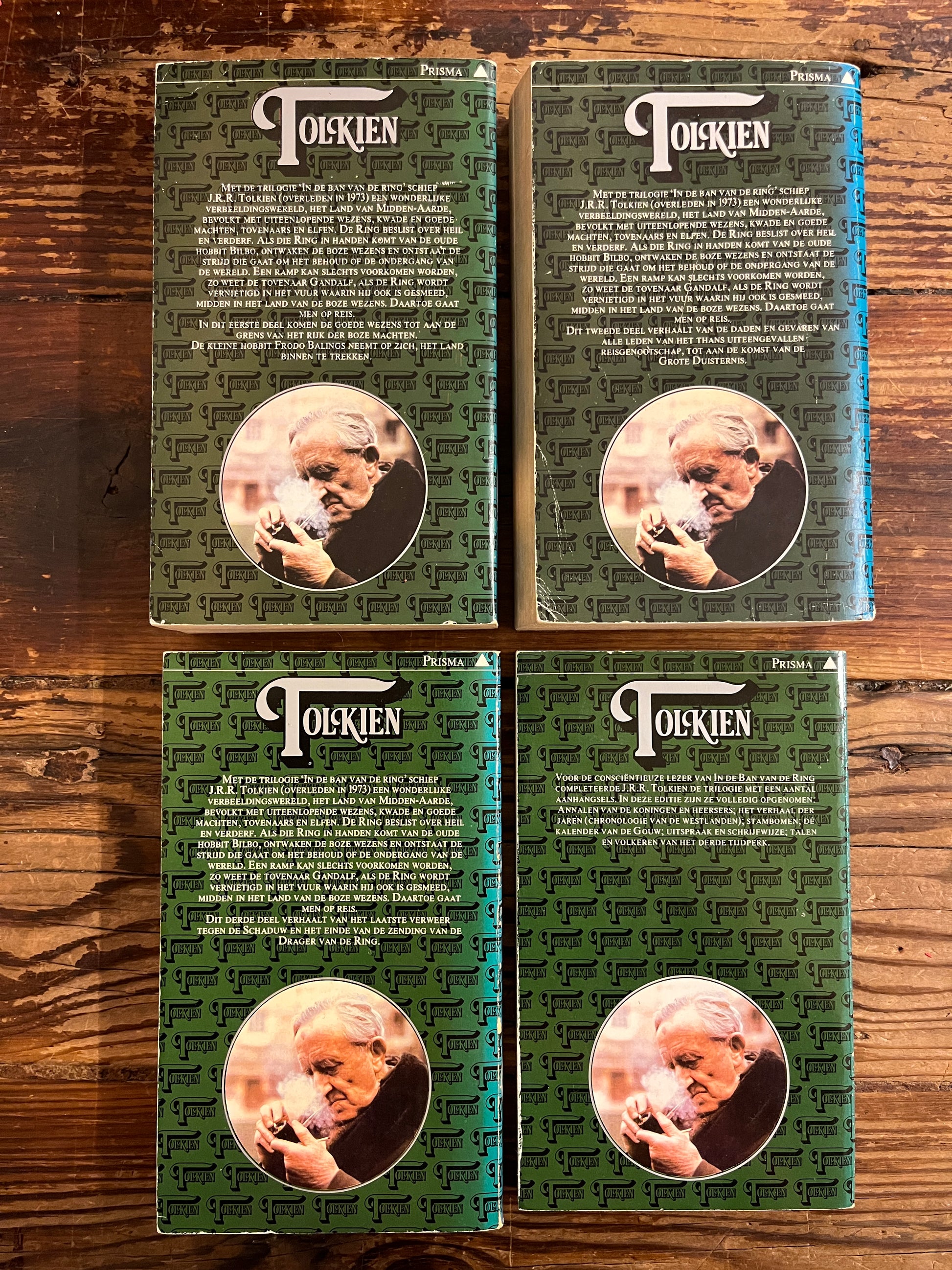 Vier boeken van Tolkien 'in de ban van de ring' deel een tot en met deel drie plus de aanhangsels op een houten achtergrond 