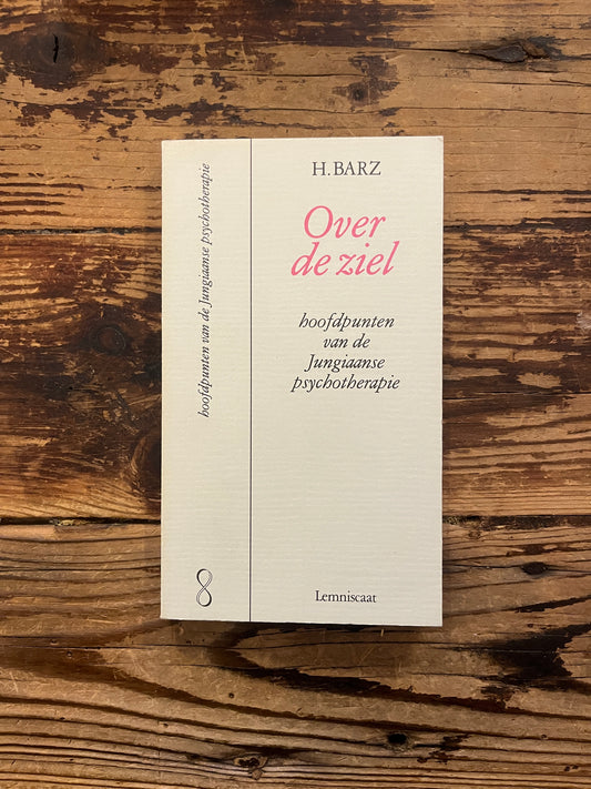 Boek met de titel 'Over de ziel, hoofdpunten in de jungiaanse psychotherapie' door H. Barz op een houten achtergrond 