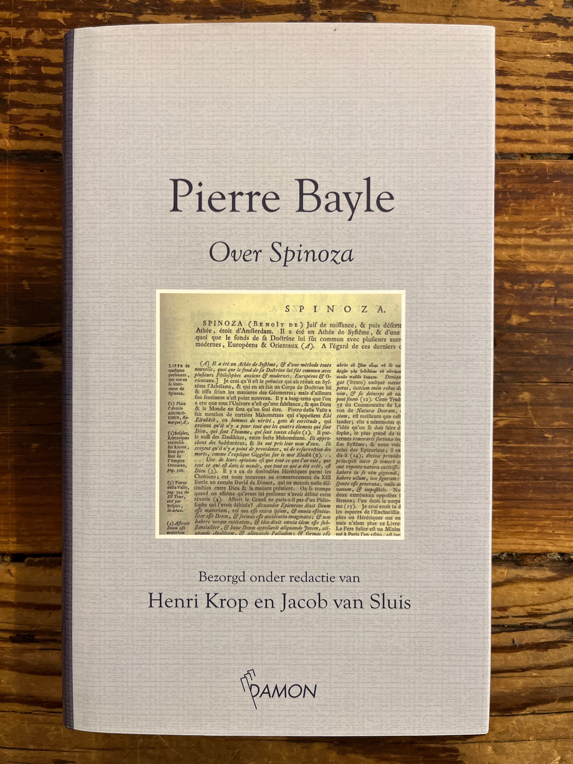 Voorkant van boek met de titel 'Pierre Bayle over Spinoza' op een houten achtergrond 