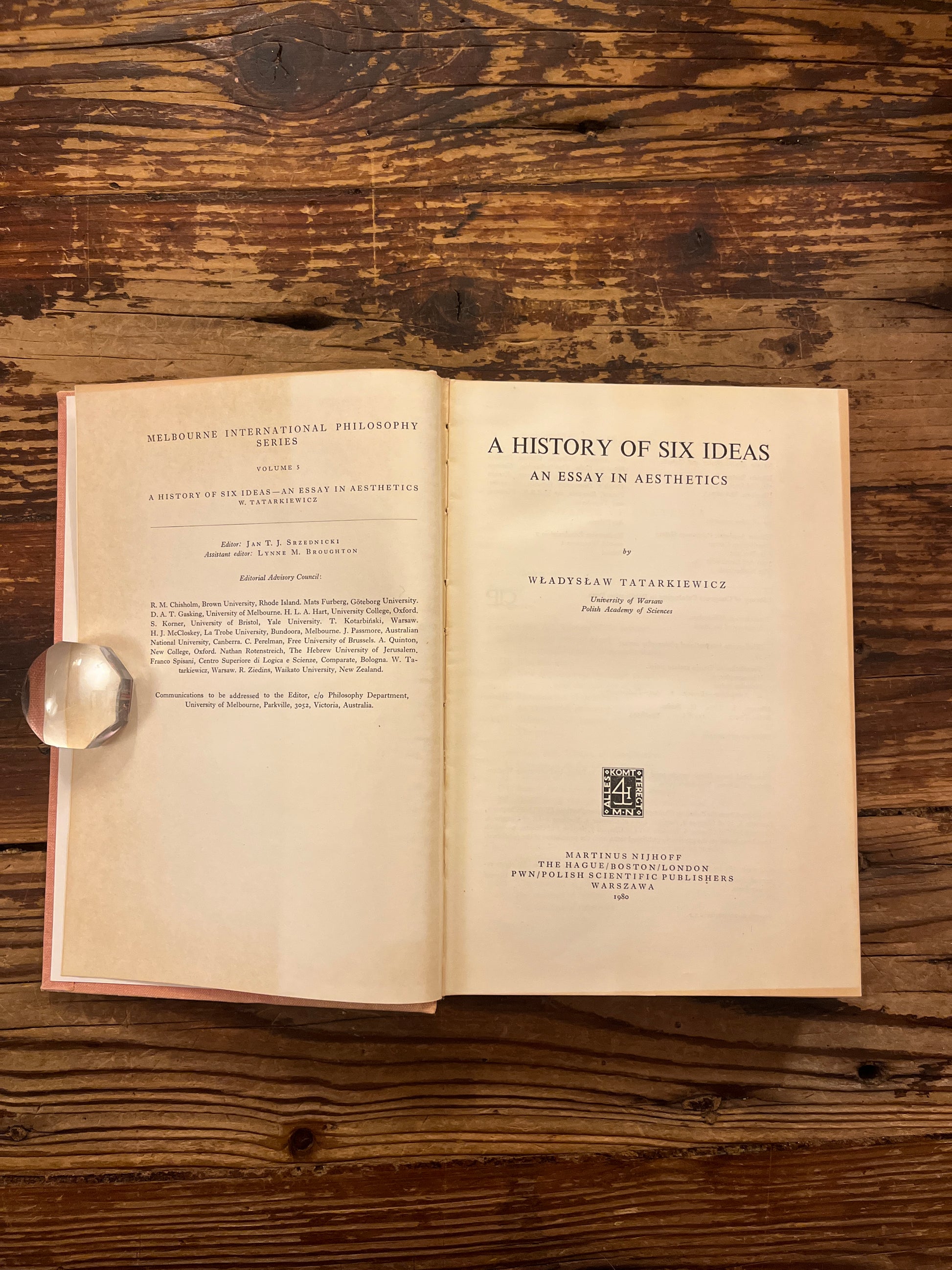 Open book titled 'A History of Six Ideas' by Wladyslaw Tatarkiewicz on a wooden surface