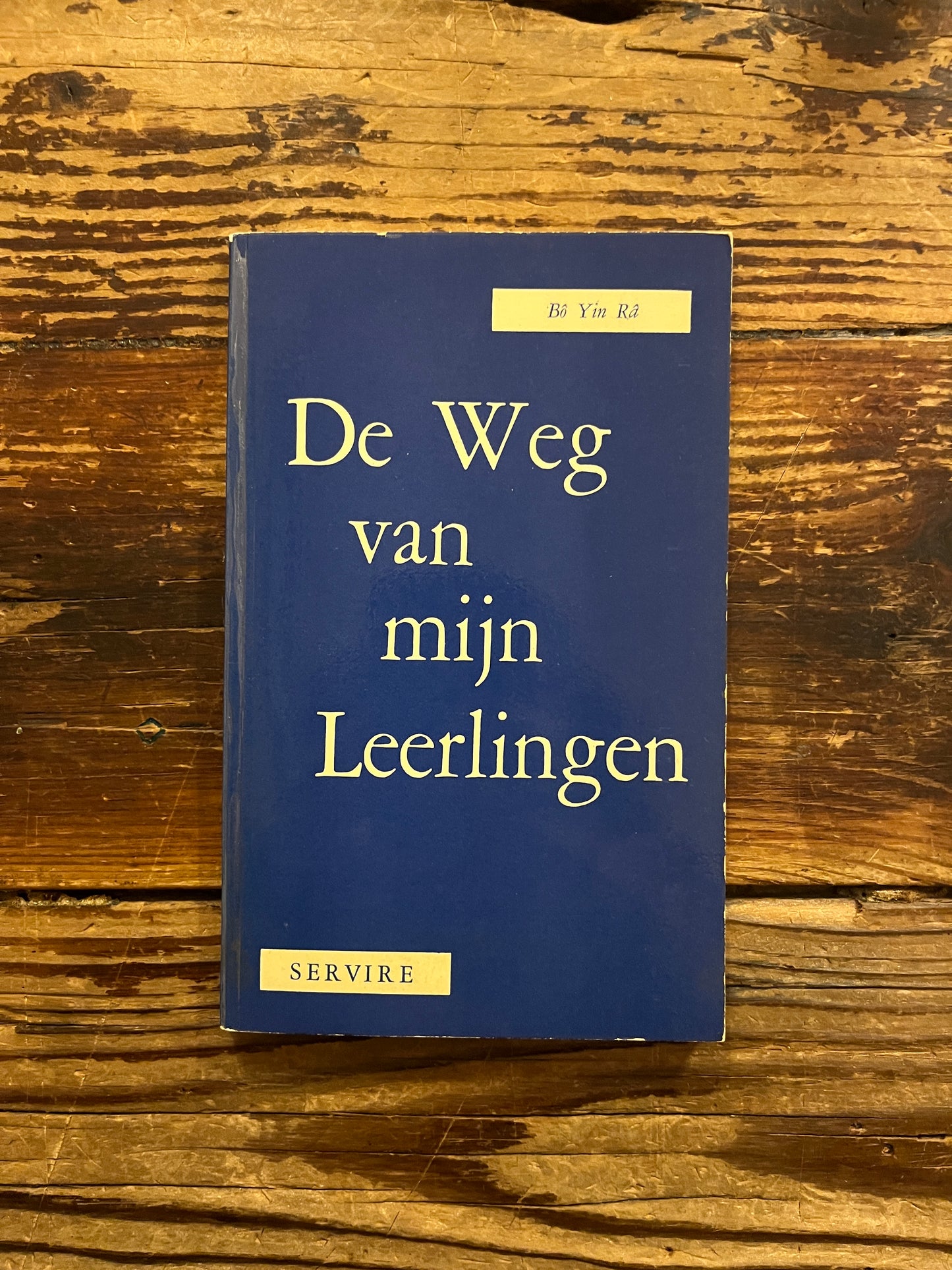 Voorkant van boek met de titel 'De Weg van Leerlingen' door Bo Yin Ra op een houten achtergrond 