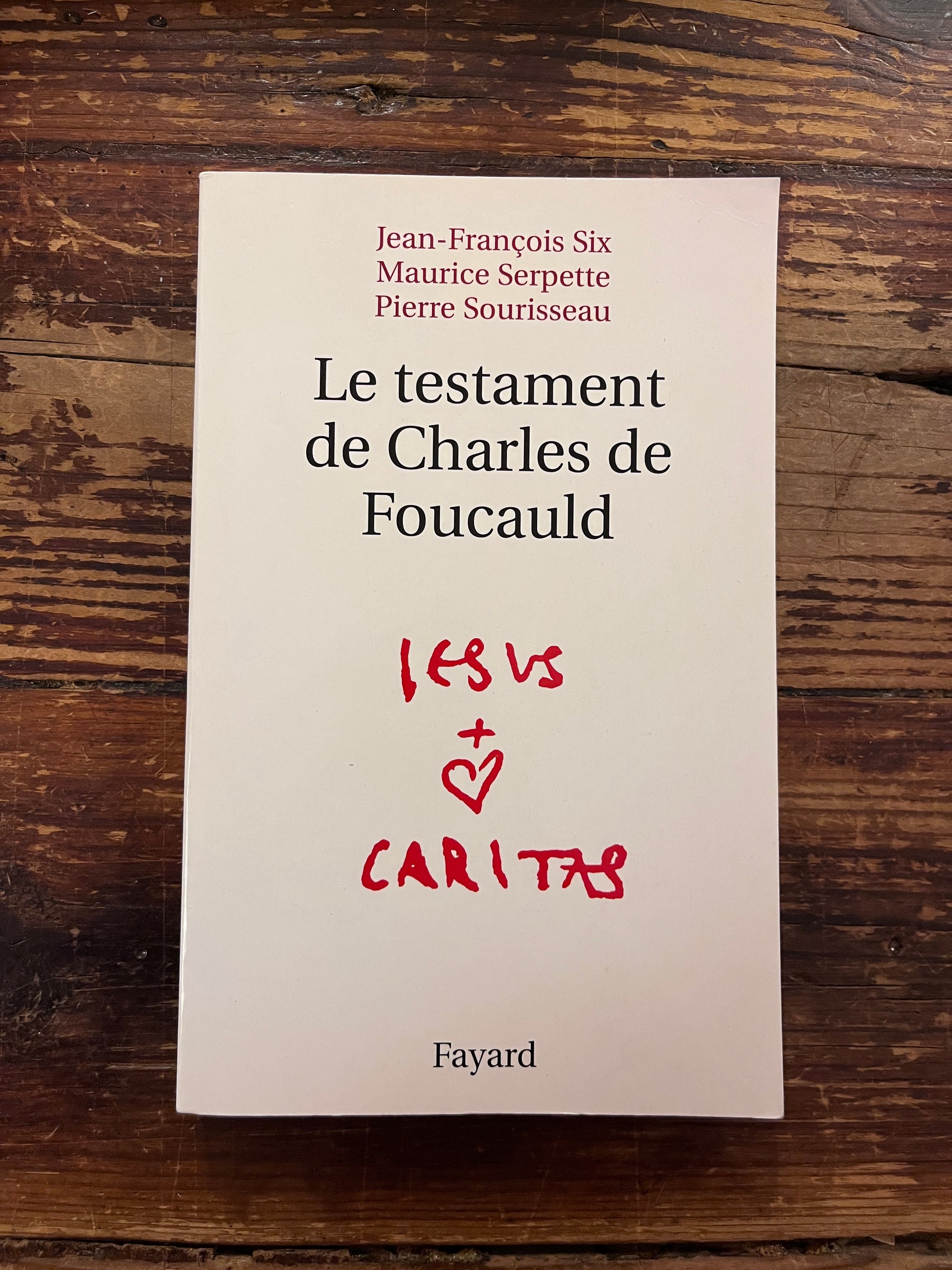 photo de la couverture du livre "le testament de charles de foucauld"sur fond de bois