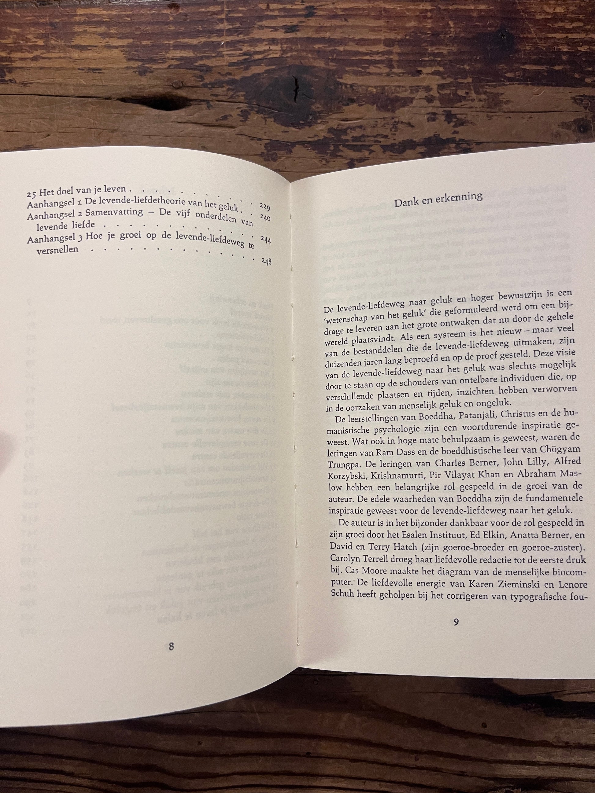 Inhoud van boek 'Handboek voor hoger bewustzijn' door Ken Keyes op een houten achtergrond 