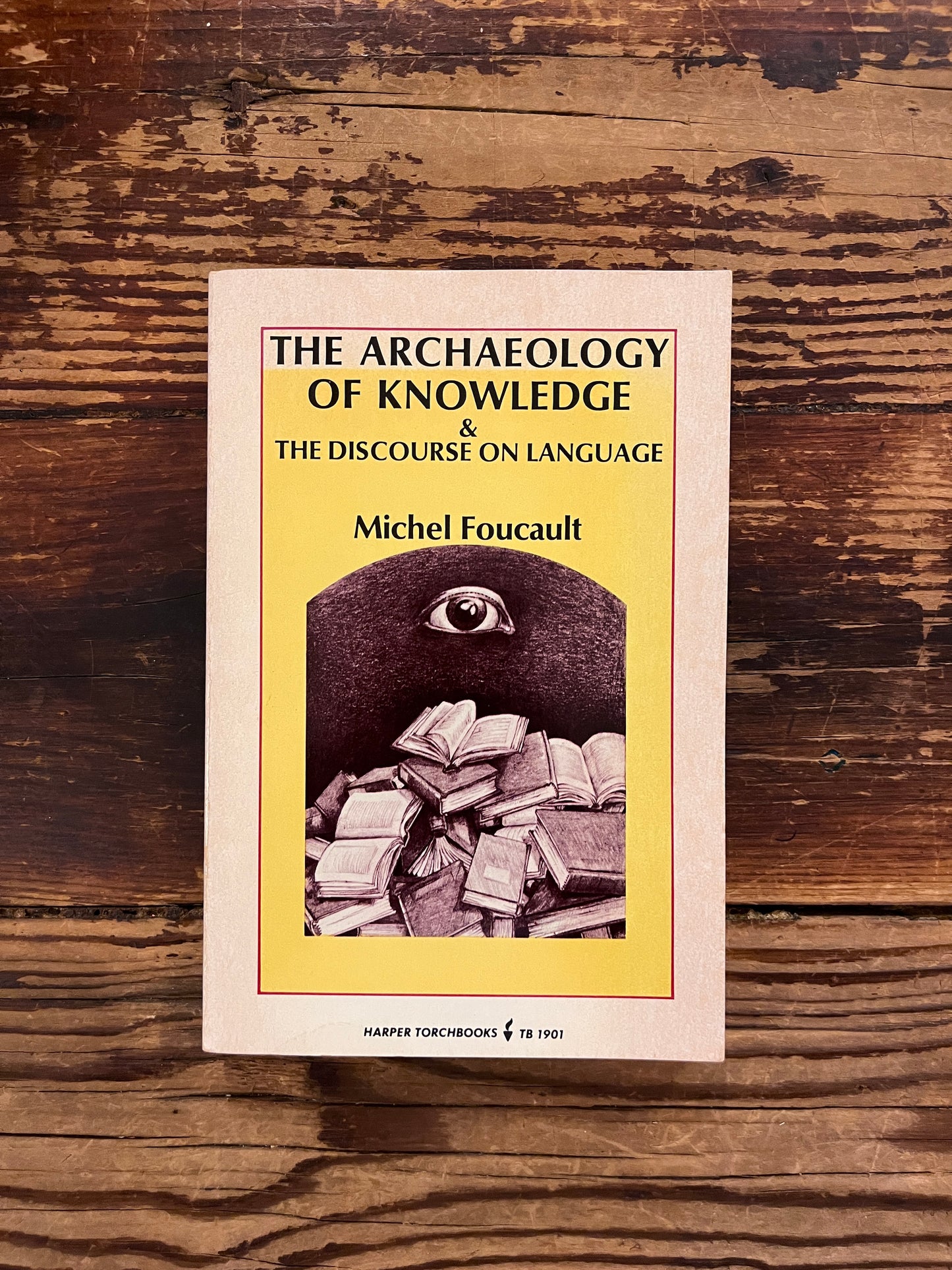 photo of the cover of the book "the archaeology of knowledge" on a wooden background