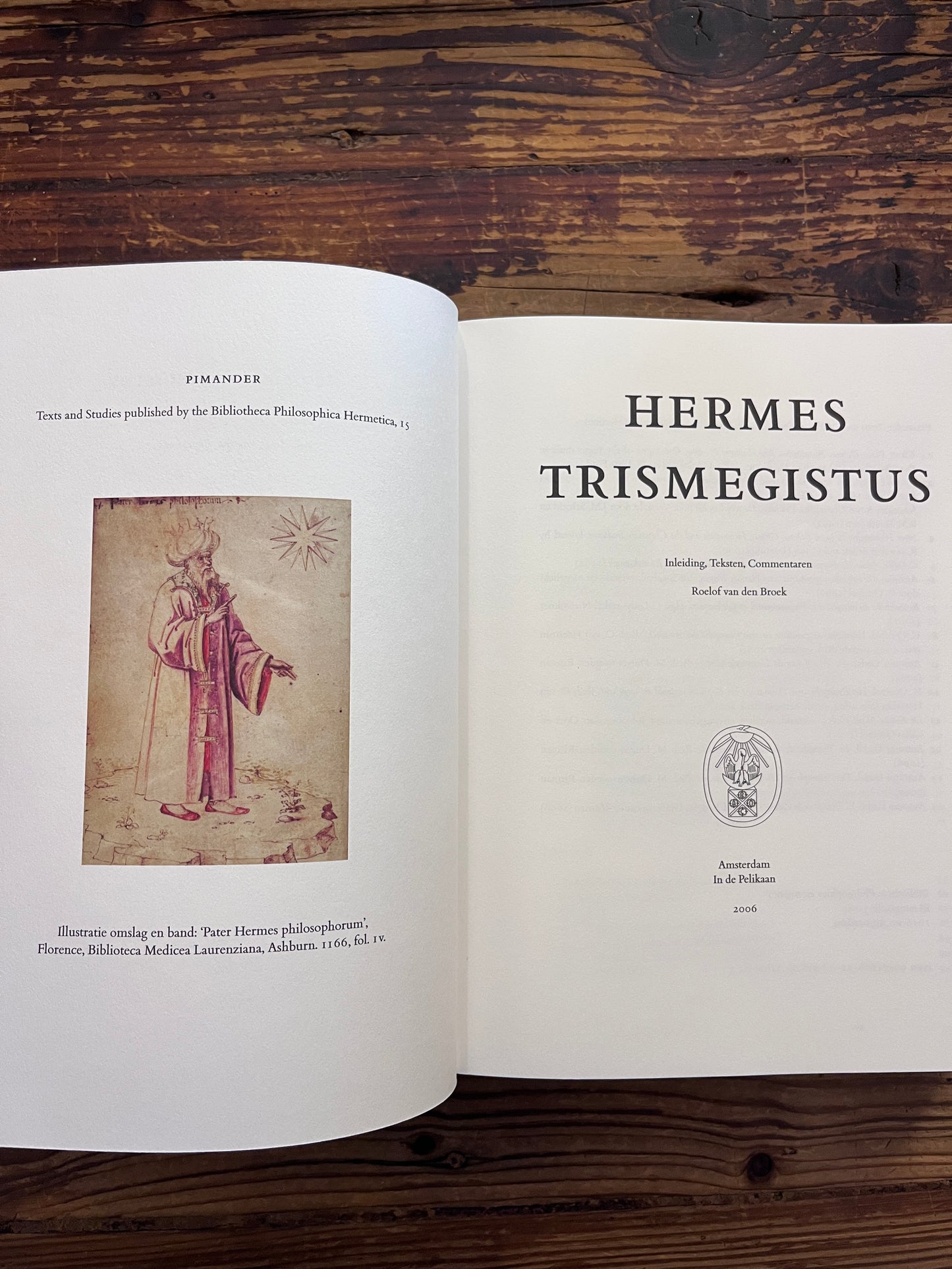 Open boek met de titel 'Hermes Trismegistus' door Van den Broek op een houten achtergrond 