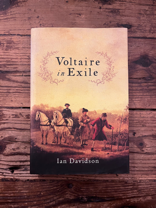 photo of the cover of the book "Voltaire in exile" on a wooden background